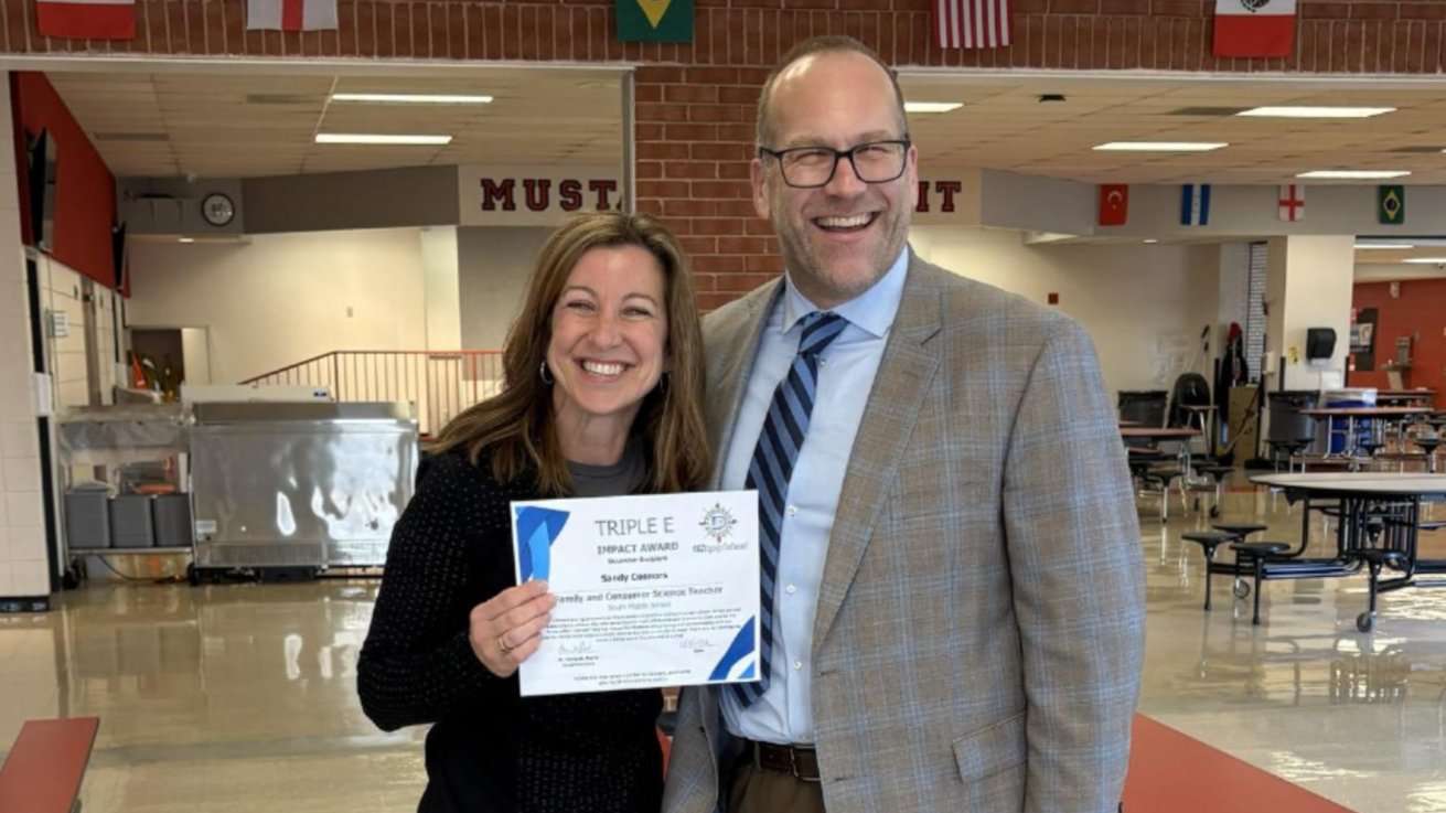 Dr. St. Pierre giving Mrs. Connors the Triple E award