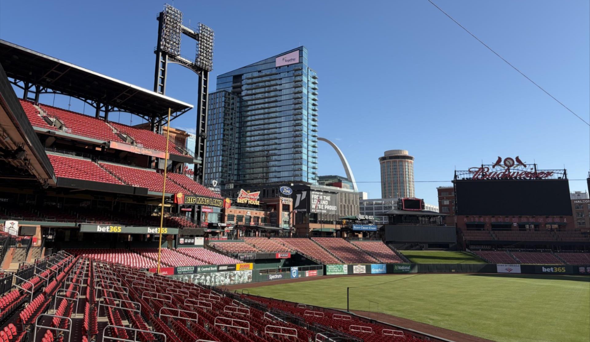 American flag, yellow sunflower, in front of a painting of a lighthouse