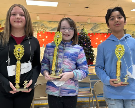 Top three spellers pose with trophees