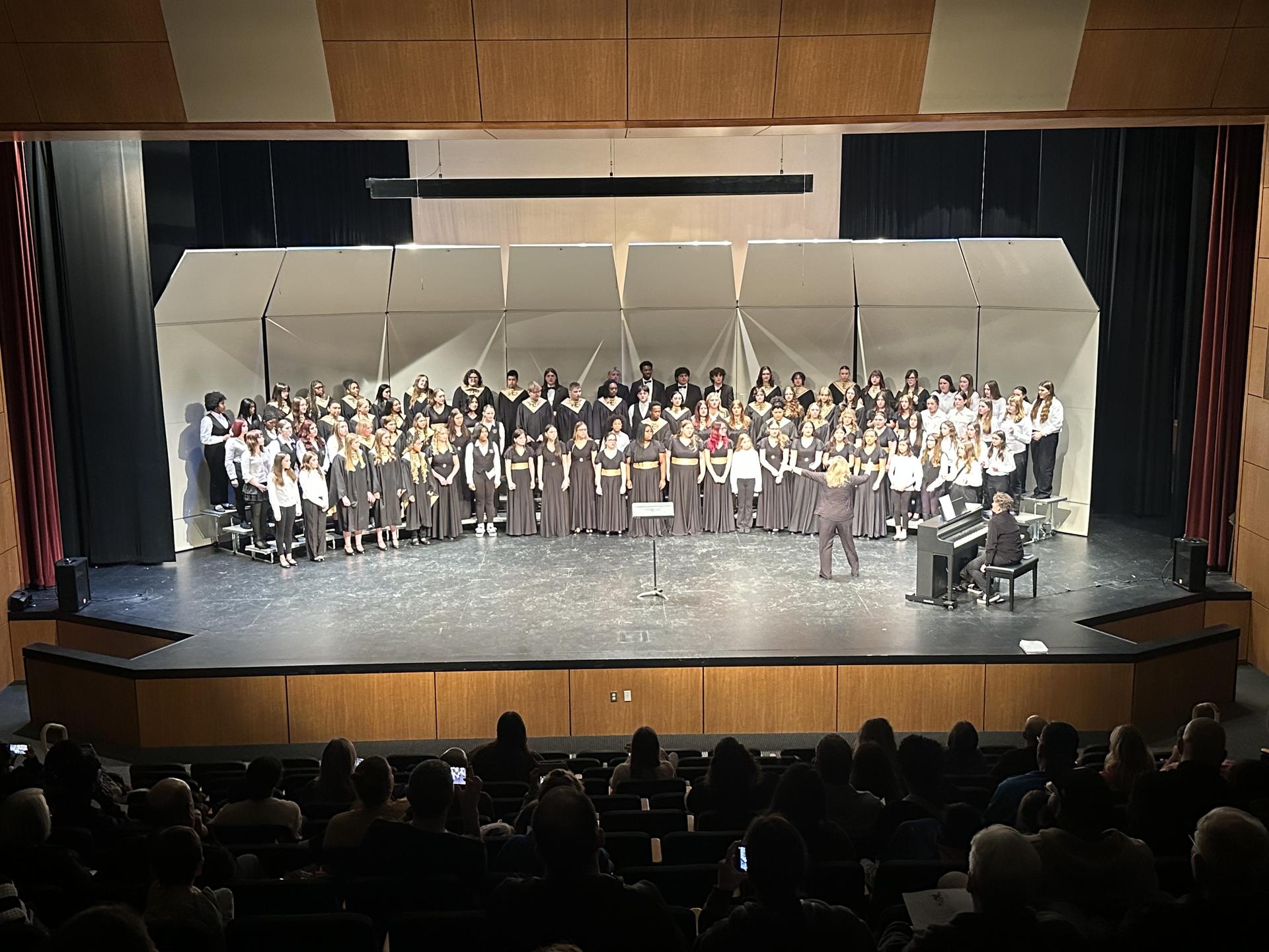 Photo of DuBray & East High Choir on stage at concert.