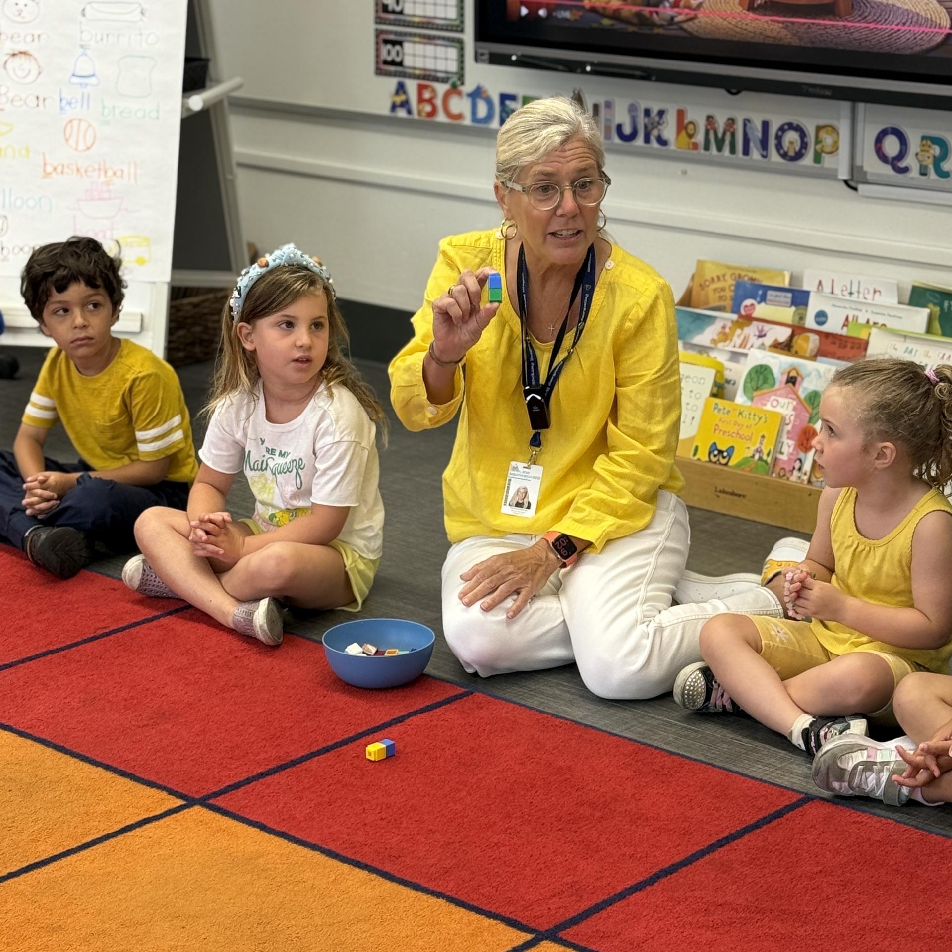 teacher and kids on rug