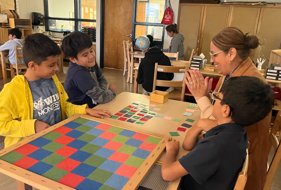 Teacher cheers while students complete math work