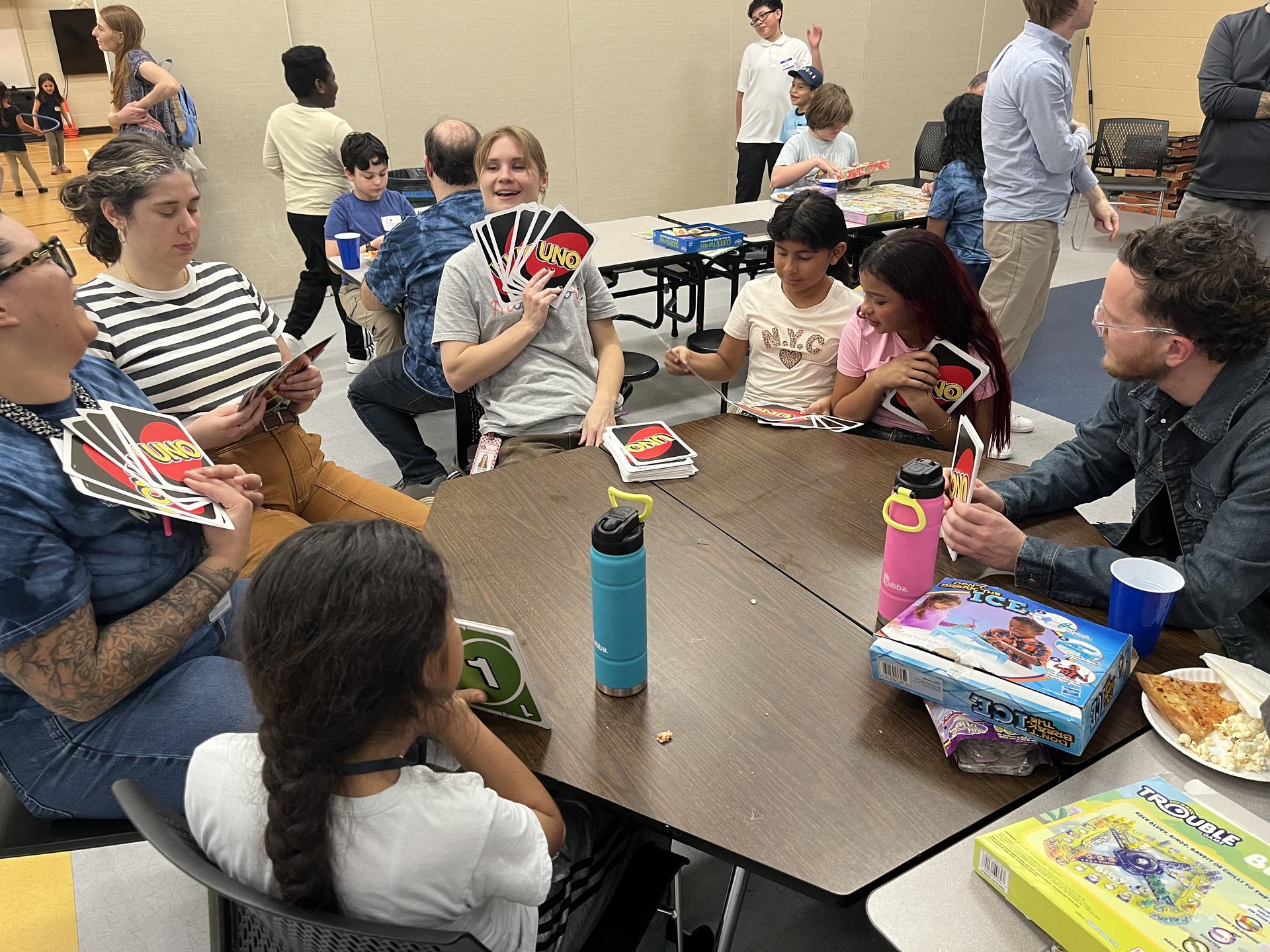 Ms. Abby, students, and families playing Uno