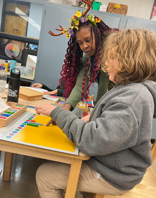 Teacher works closely with student on the decimal board