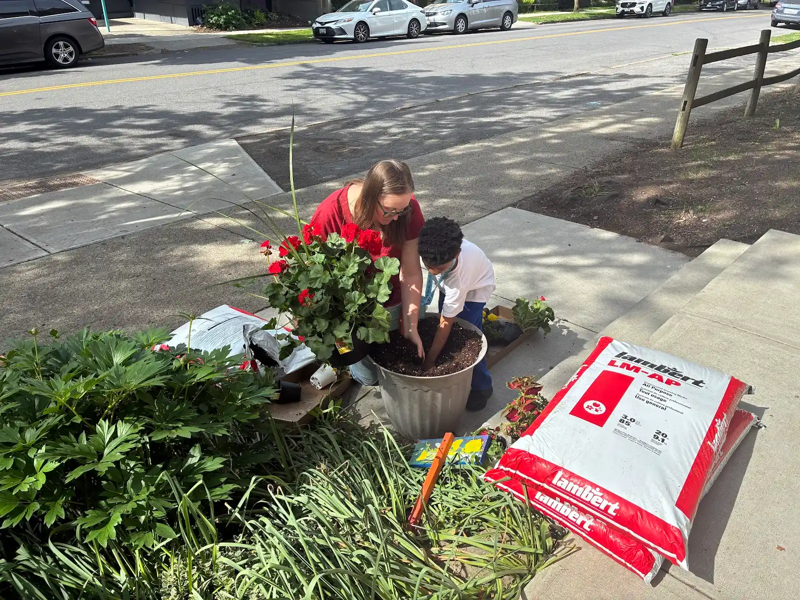 BJM students outside the school building spreading mulch and cleaning up the garden beds. 