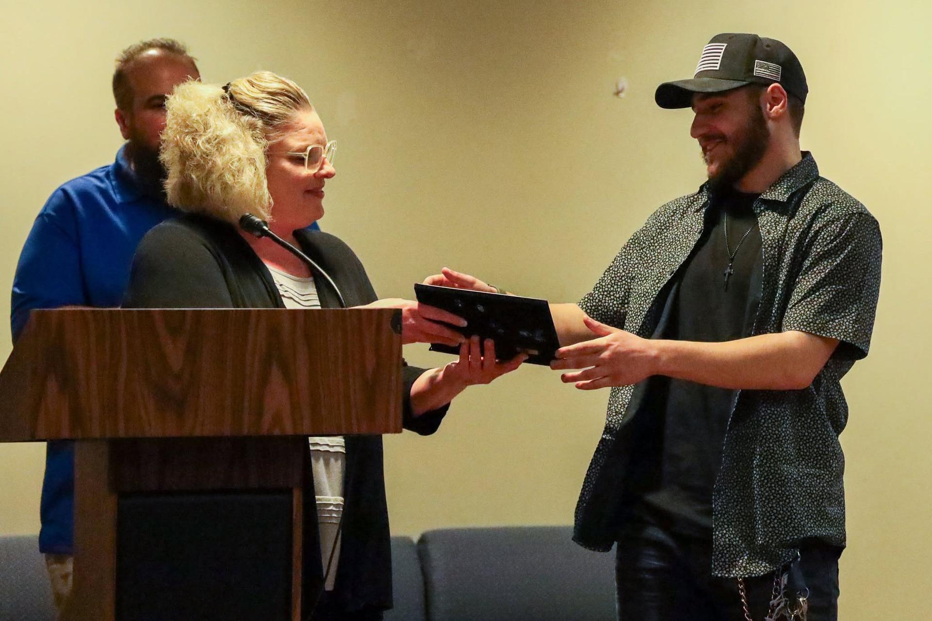 Michael Grecco receiving award on stage from teachers