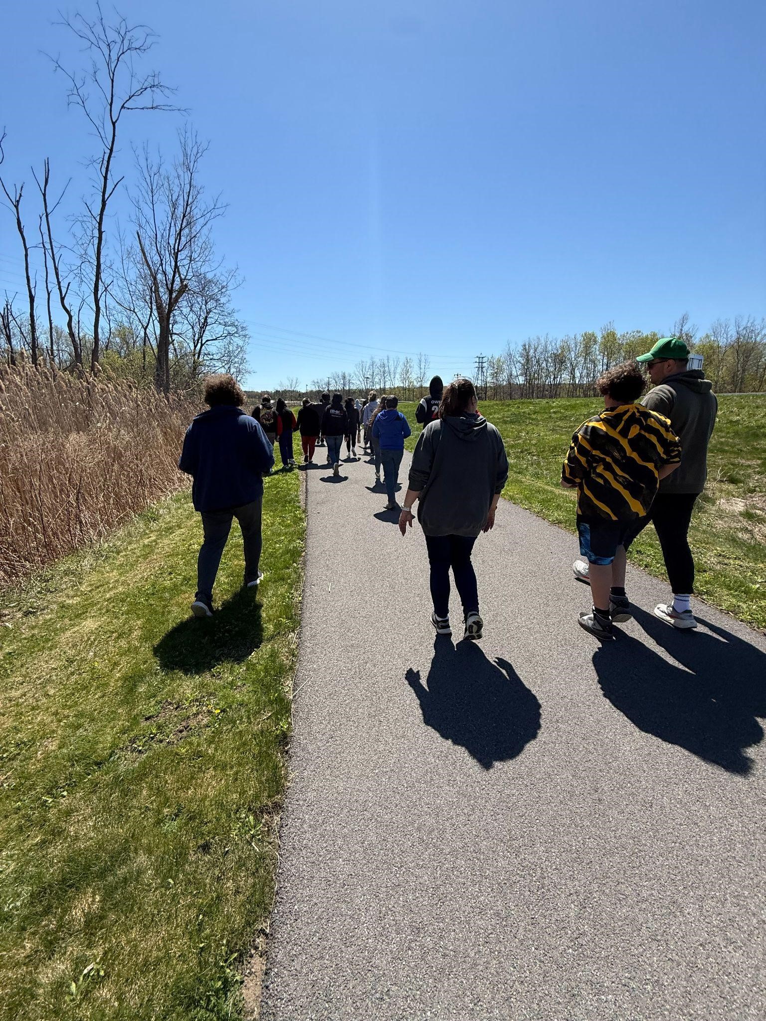 Many students and teachers walking along a path outside