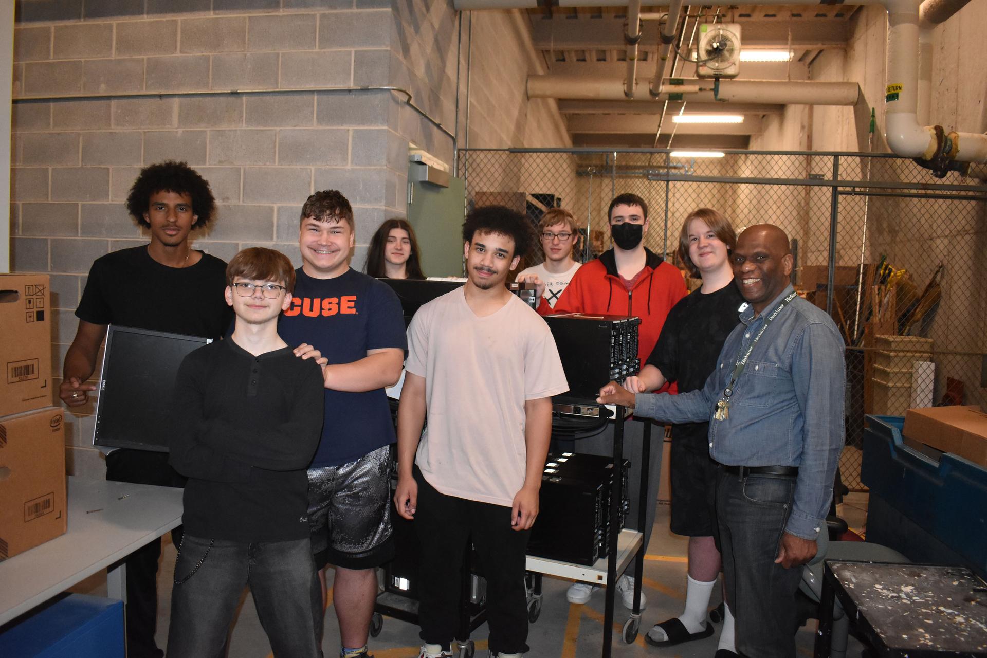 Network Administration students and teacher posing in IT storage room at Herkimer College