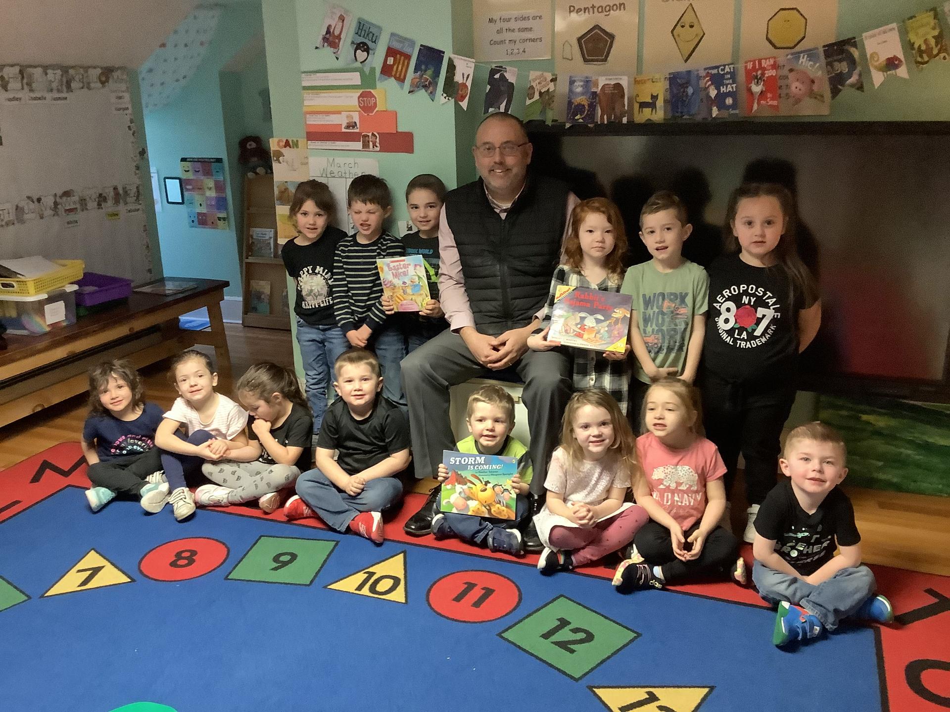 D.J. Shepardson posing with PreK students for a photo