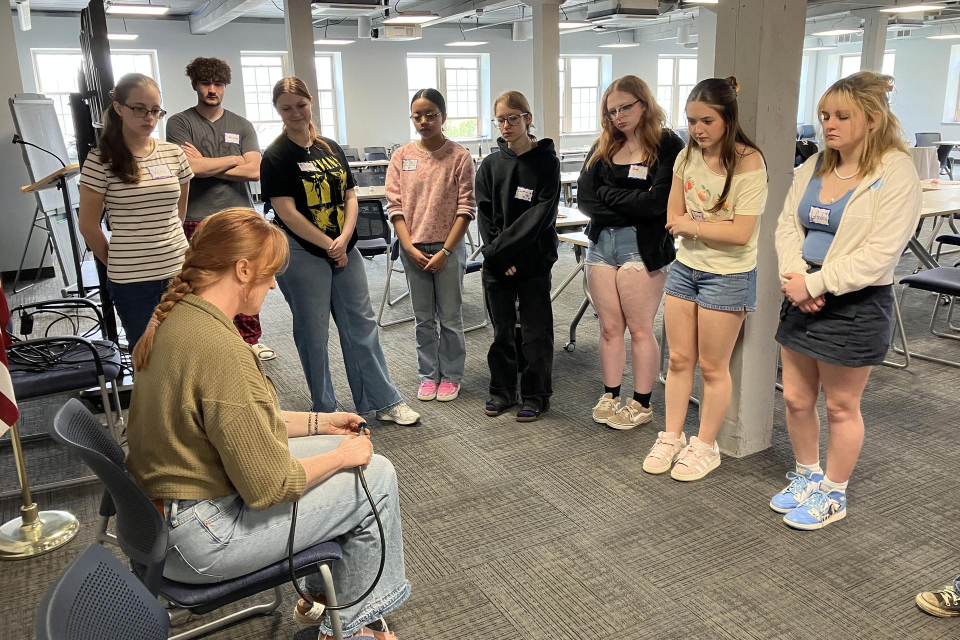 Students looking on to sitting presenter's demonstration