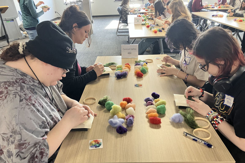 Four students working on needle felting at a table
