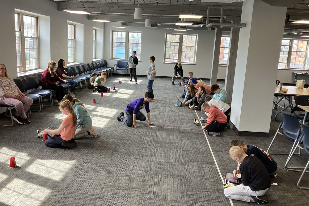 Students using robotics on the floor