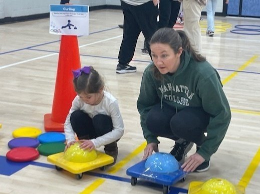 A mother and daughter participating in the curling event