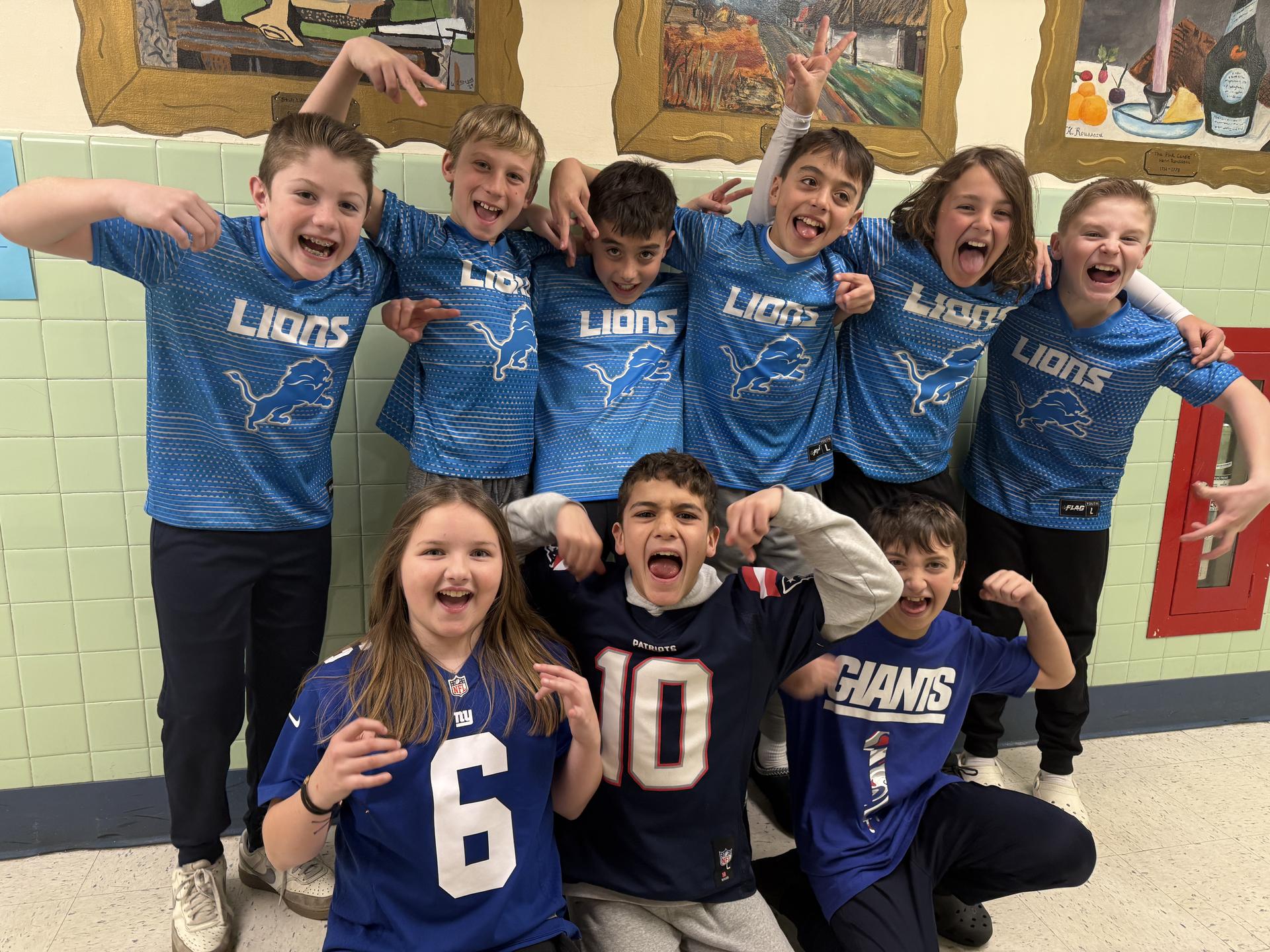 A group of students with their arms around one another, wearing jerseys and yelling excitedly