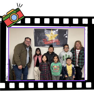 6 STUDENTS WITH 2 ADULTS STANDING IN FRONT OF BLACK POSTER FOR STUDENTSOF THE WEEK