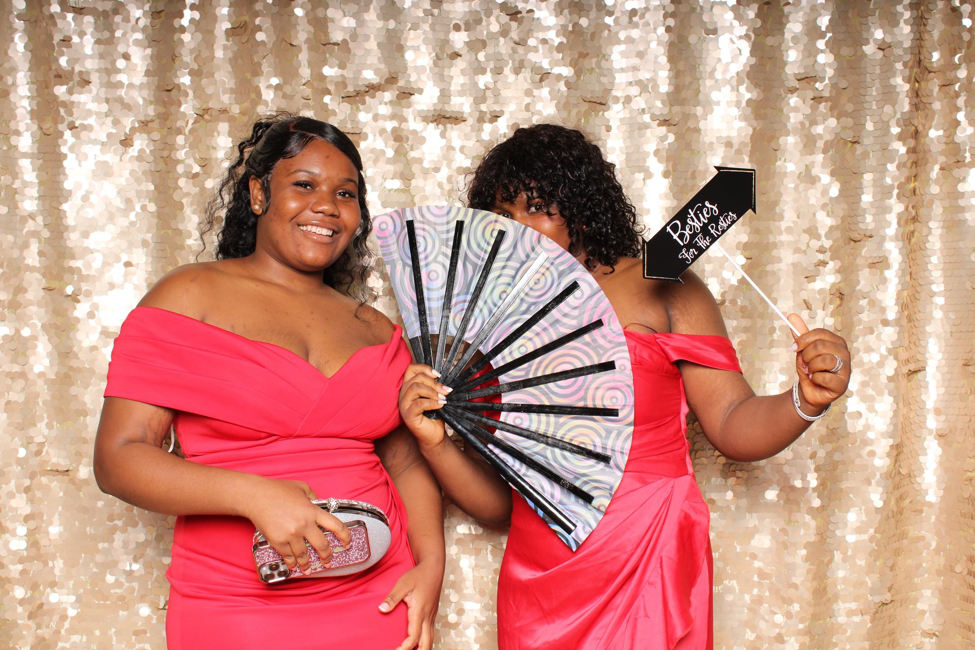 Two NEC students post in a photo booth at homecoming