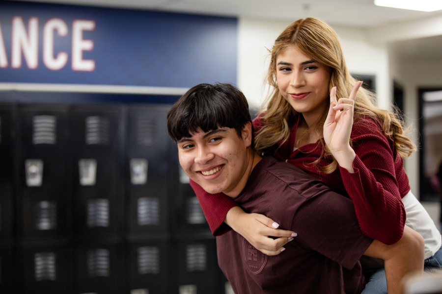 students doing piggy back ride and smiling