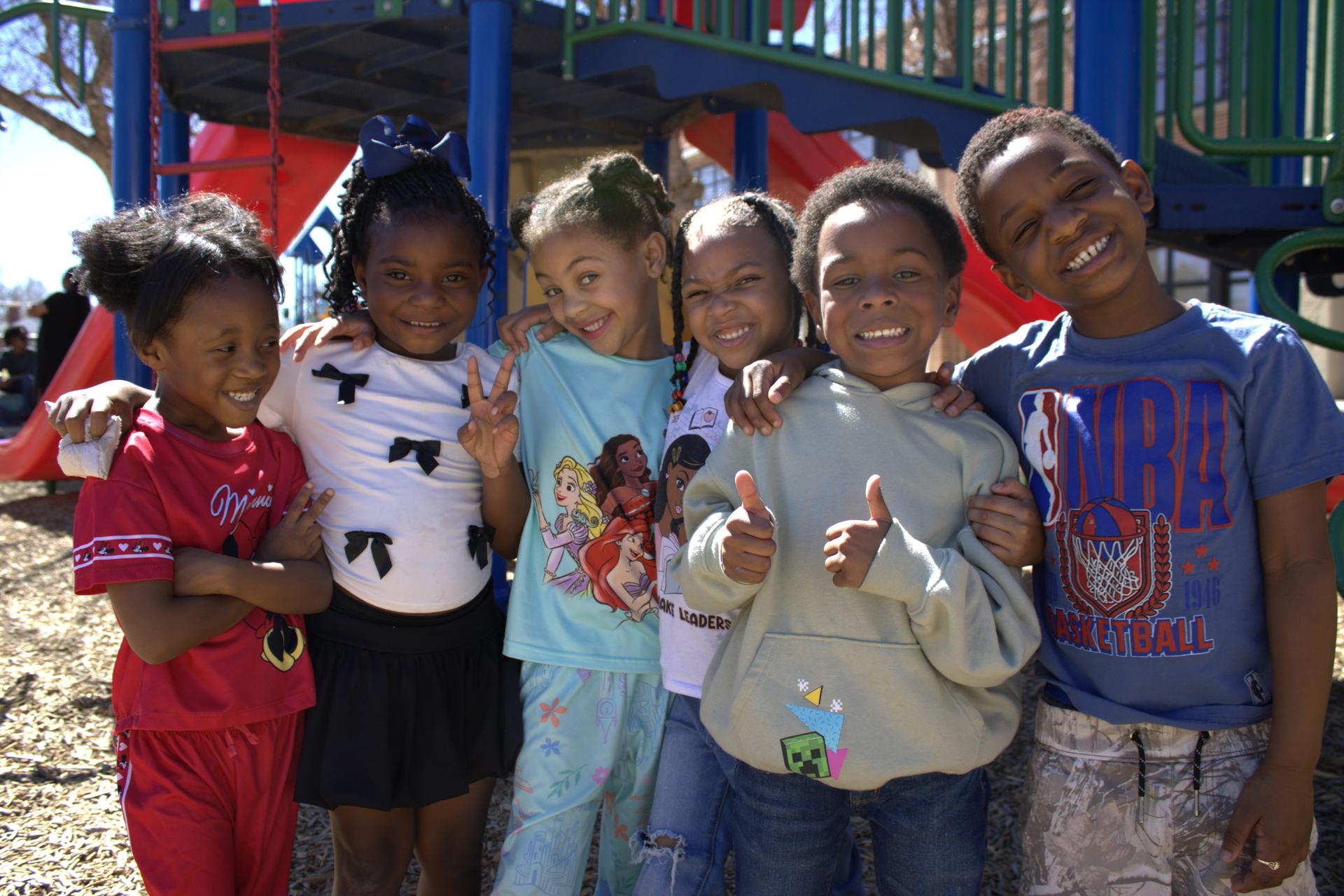 Kindergarteners smile on the playground