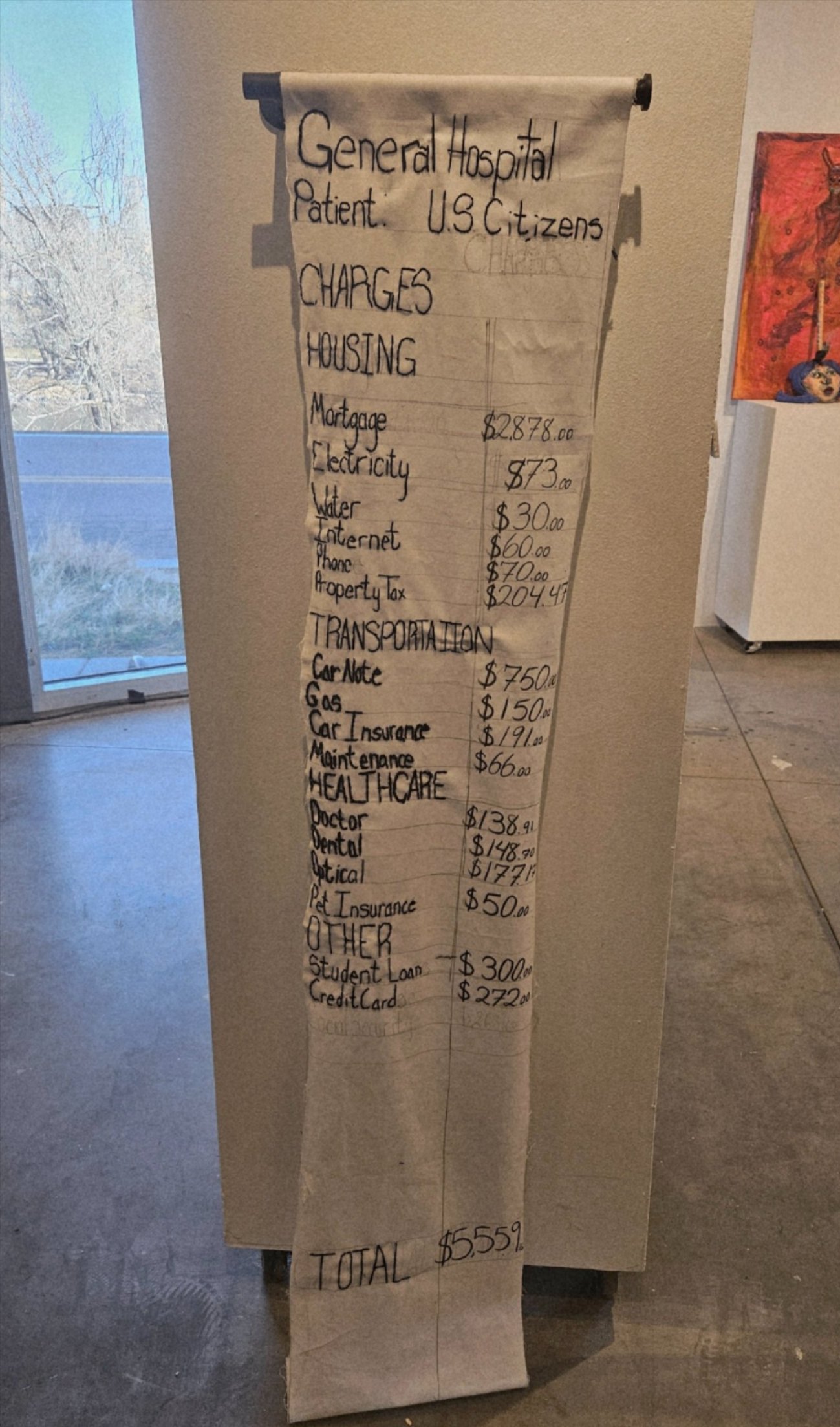 Textile art piece on display, a large scroll of expenses.