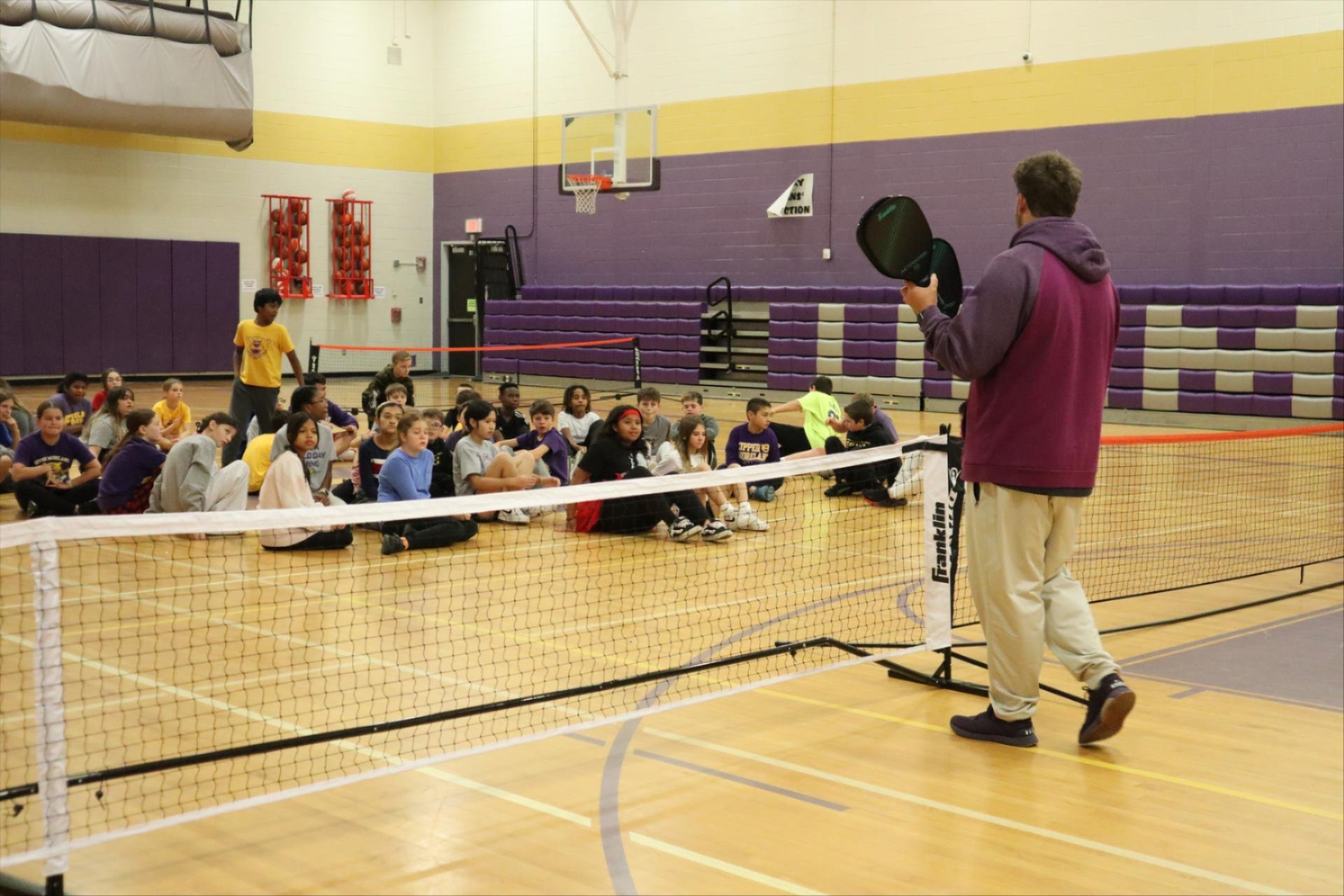 Teacher instructing students on how to play Pickleball.