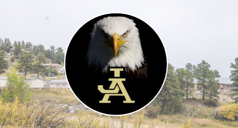 Picture of JA Eagle mascot, with school in background.