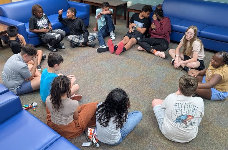 Students sit in a circle to play Bop-It.