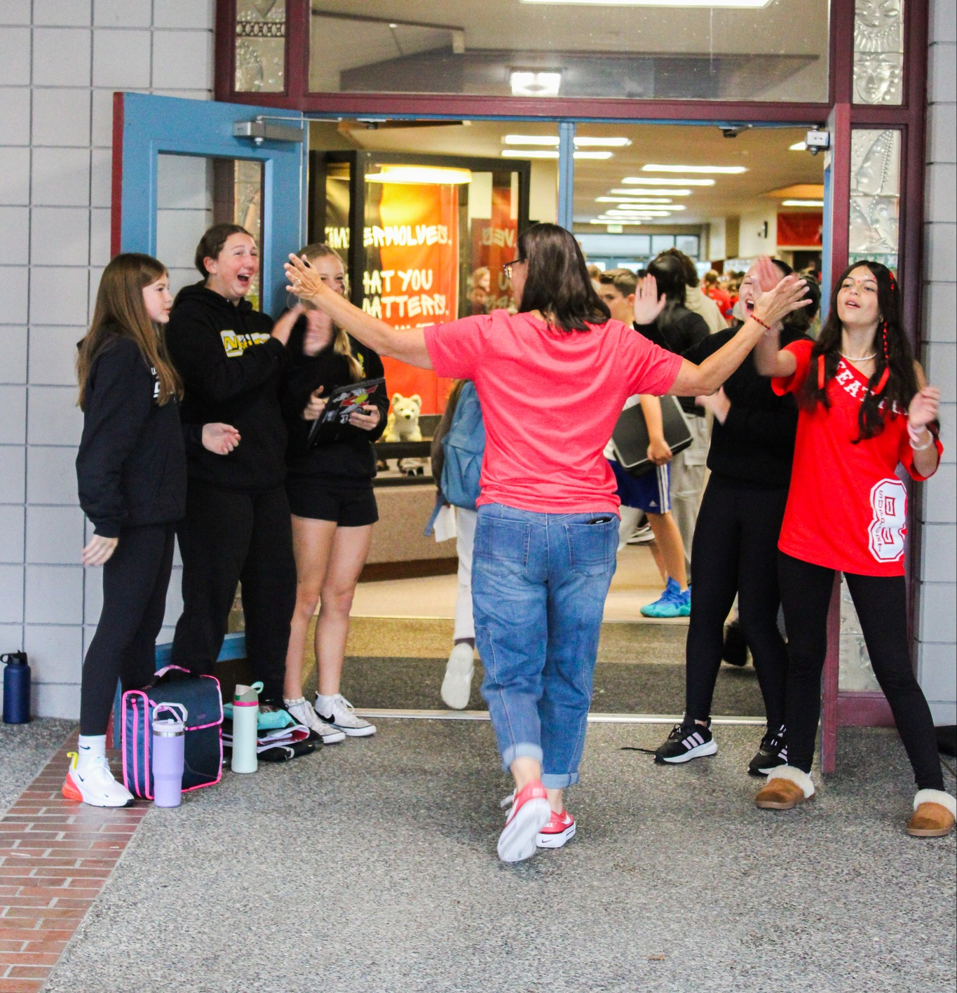 EMS students greeting people at the door with high fives