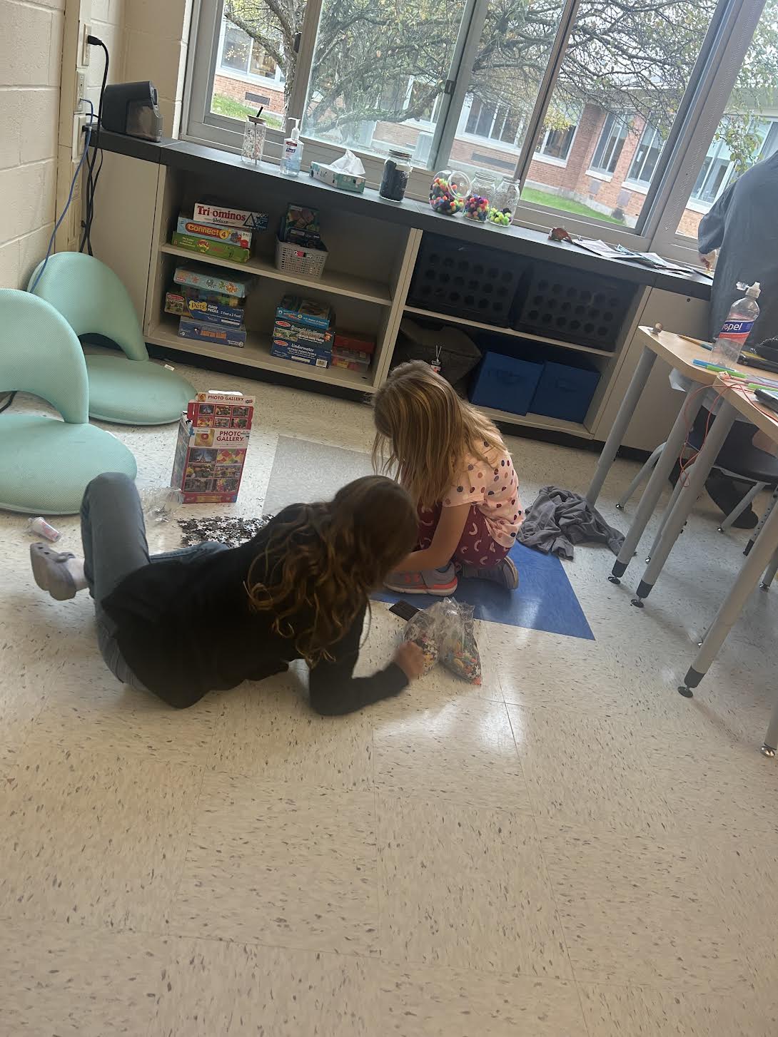 Two students work on a floor puzzle