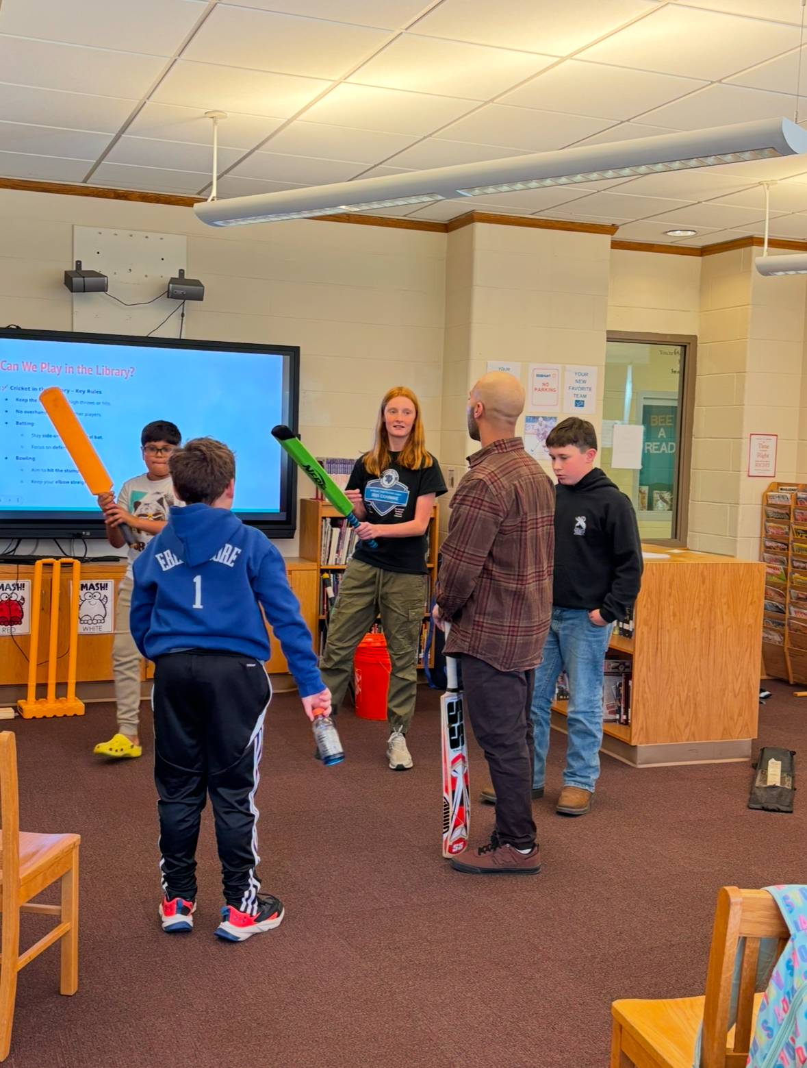Cricket in the library - students hold Cricket gear