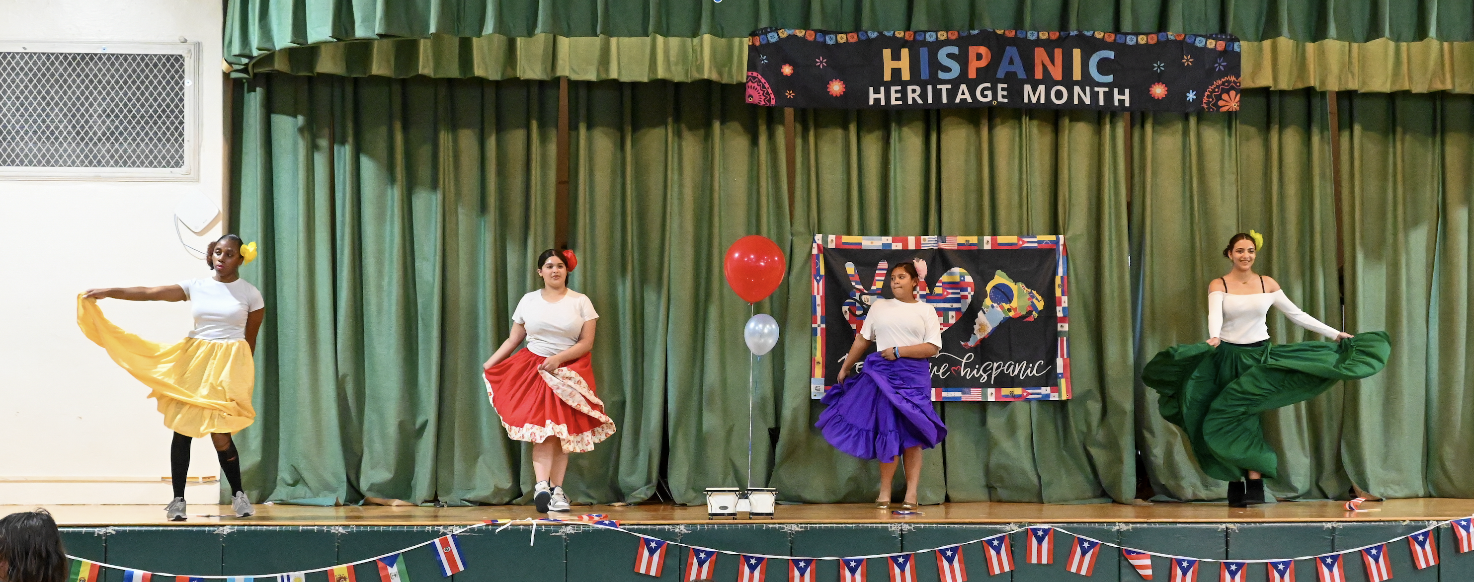 Four students dancing on stage at Metcalf