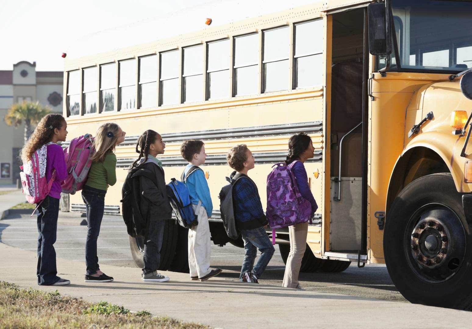 line of kids about to enter a school bus