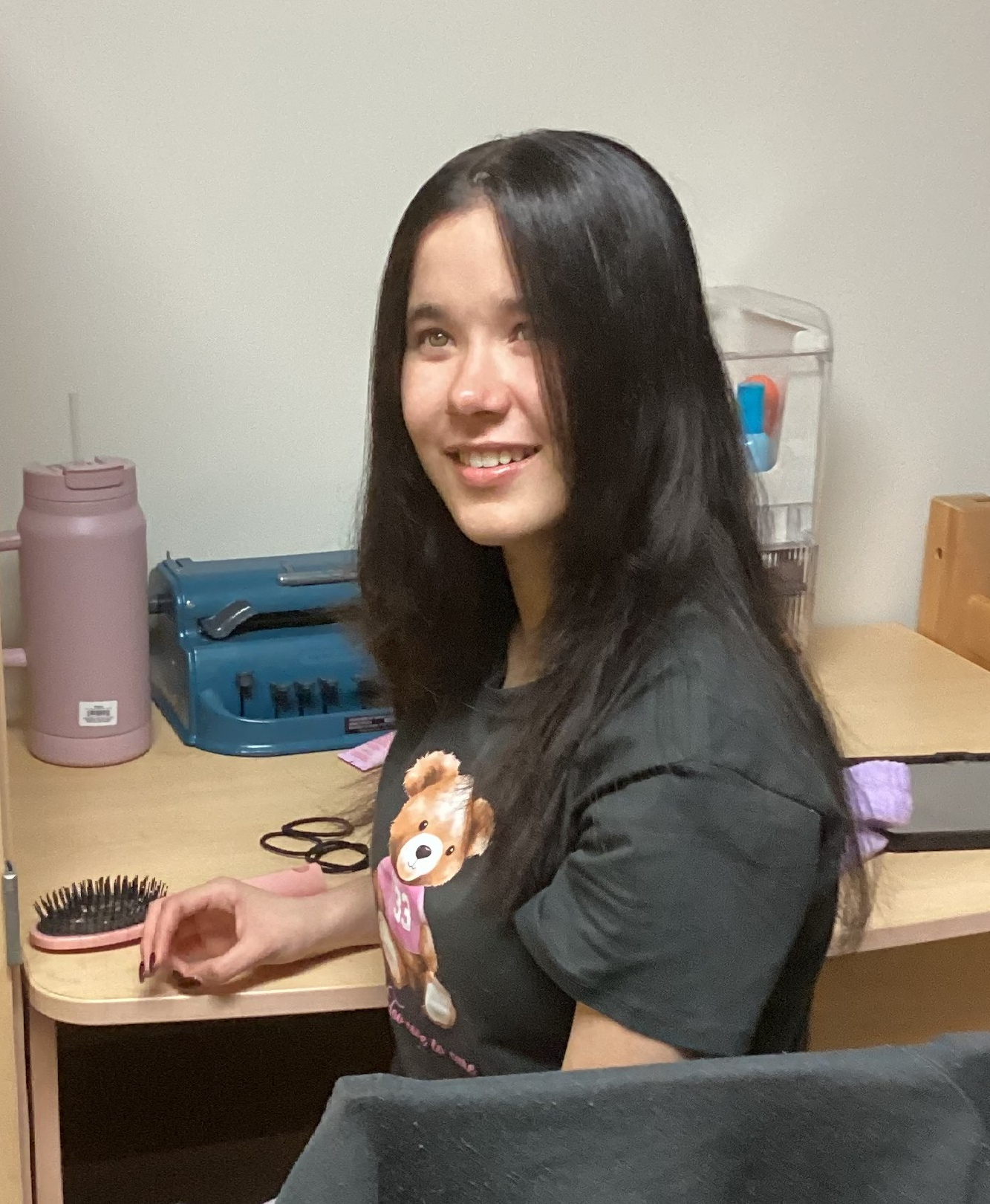 Barbara sitting at her desk turning to the camera with a smile