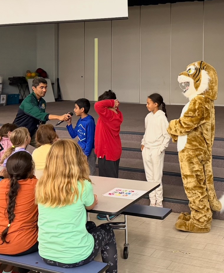 Students at assembly with a wildcat mascot