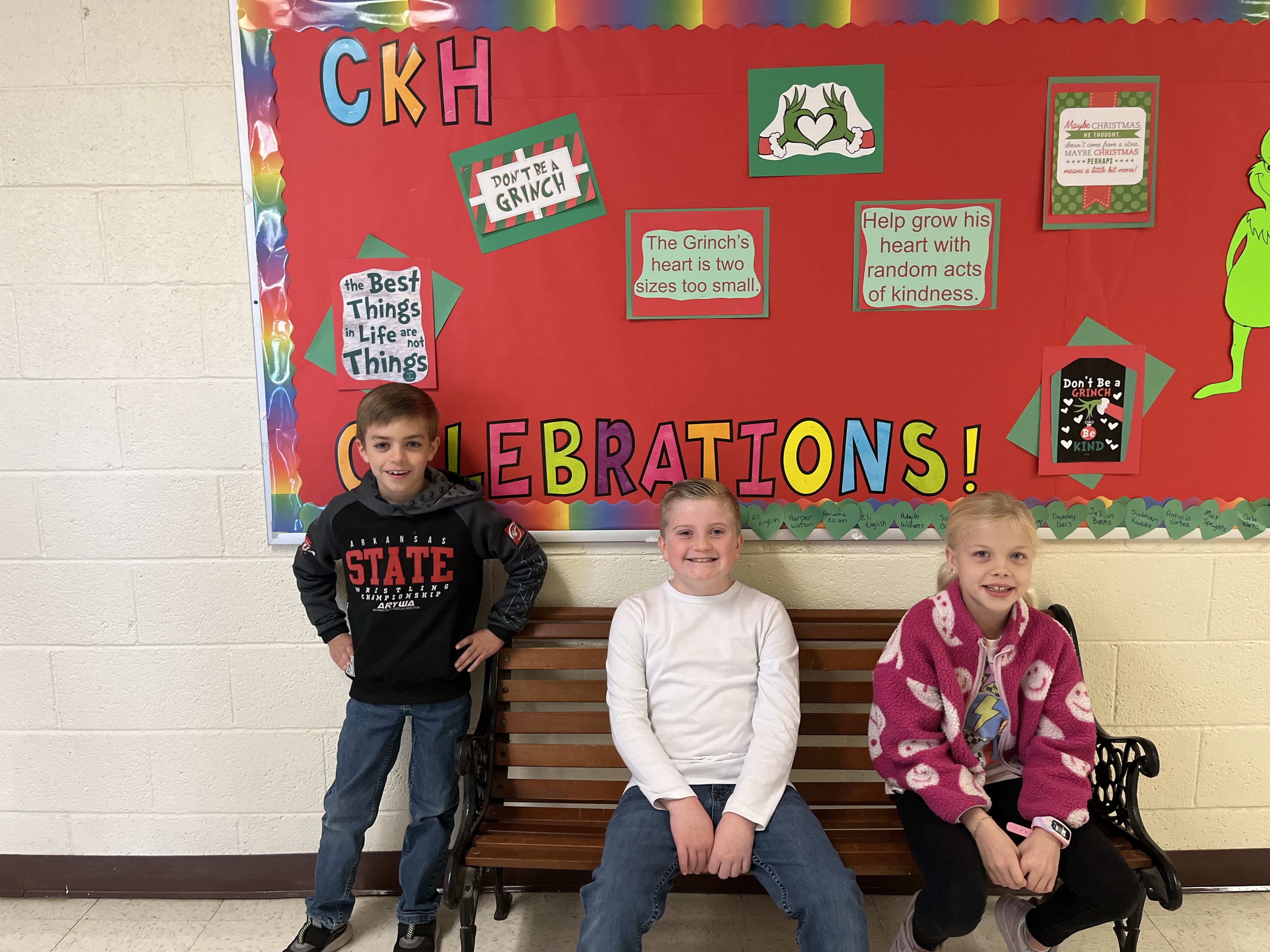 3rd grade winners smiling for the camera in front of a red bulletin board
