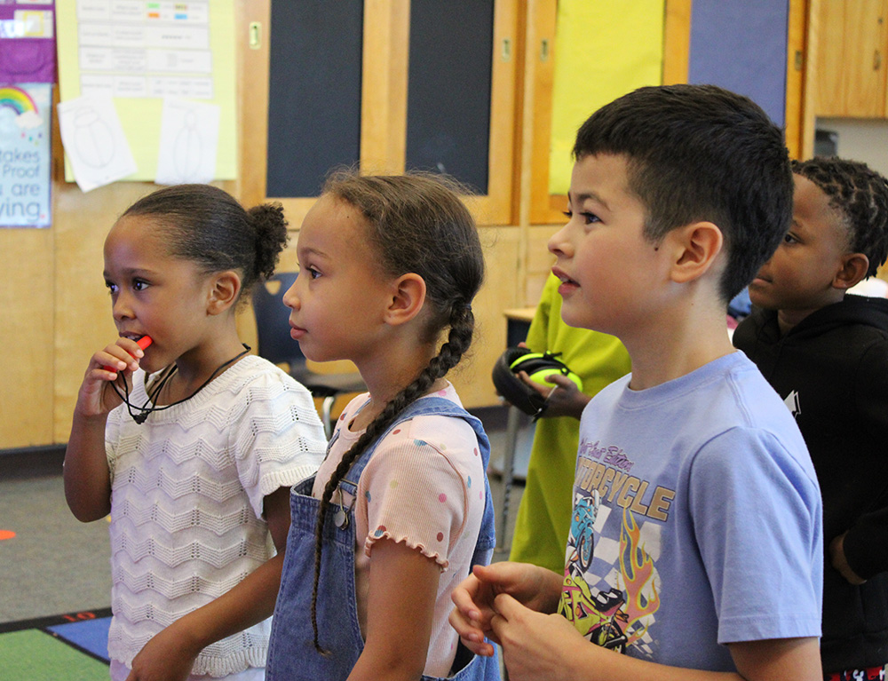 3 students watching the front of the classroom