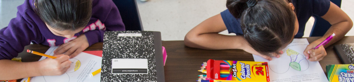 photo of students writing on a paper.