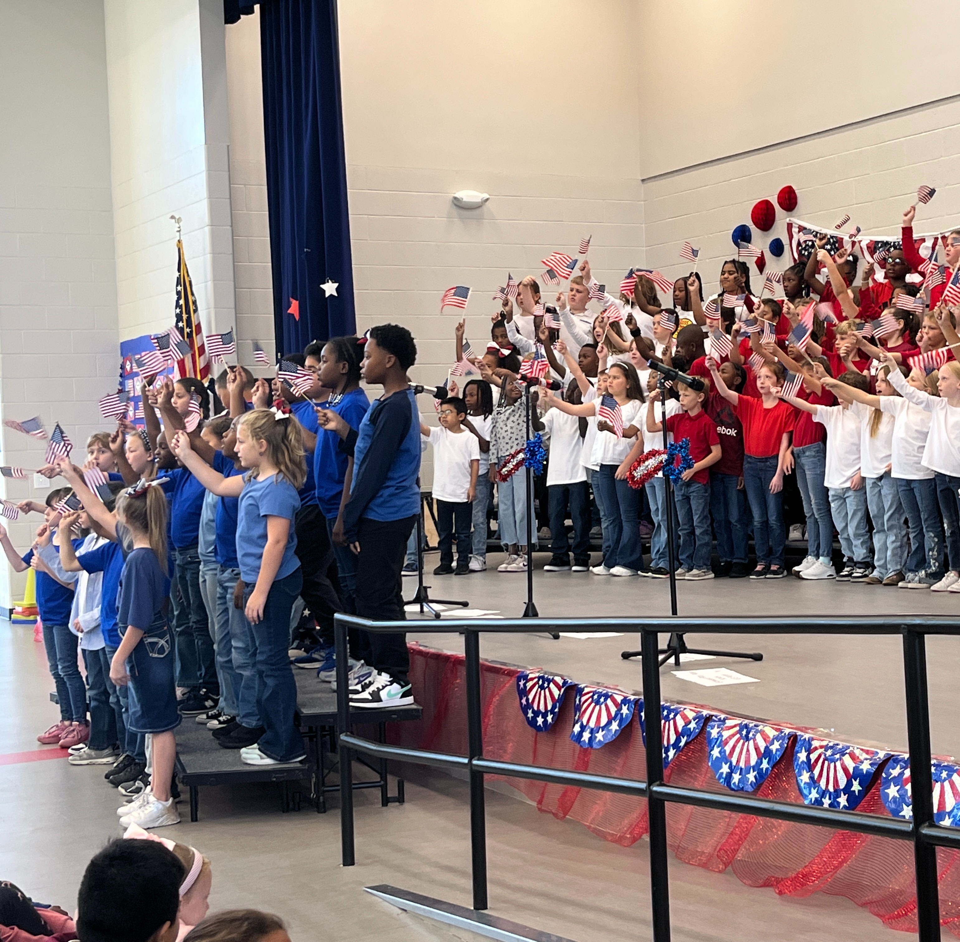 students on stage in red, white, and blue