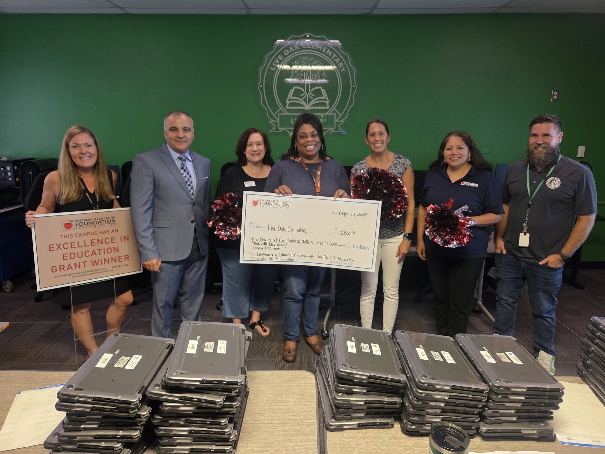 Picture of district and campus leaders with a large check for a grant