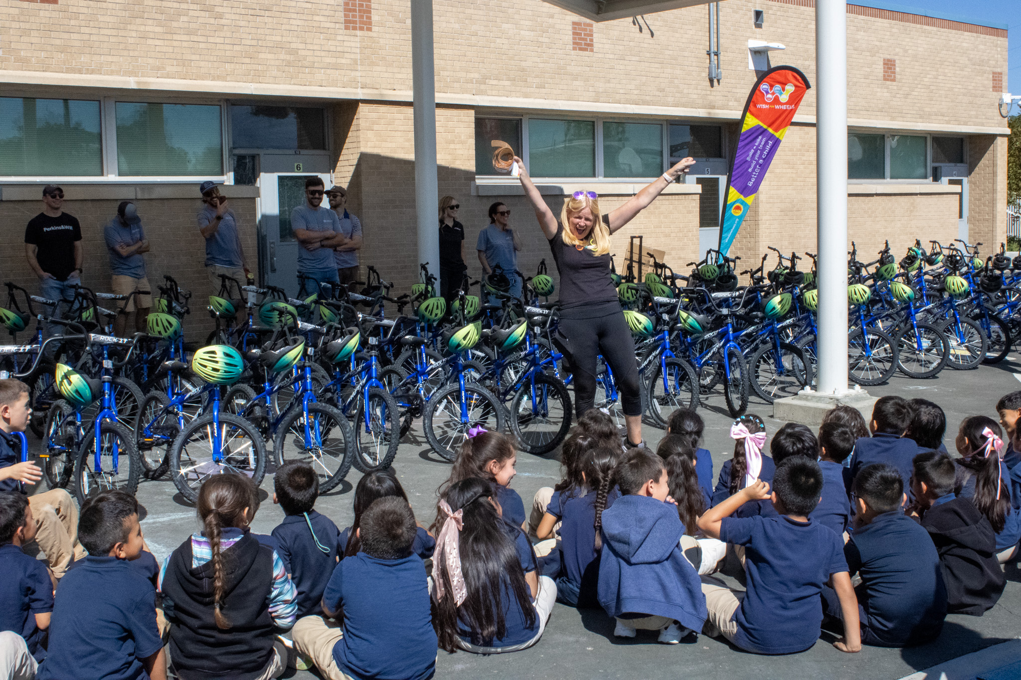 Wish for Wheels Director cheers as she announces that second graders will be getting free bikes.