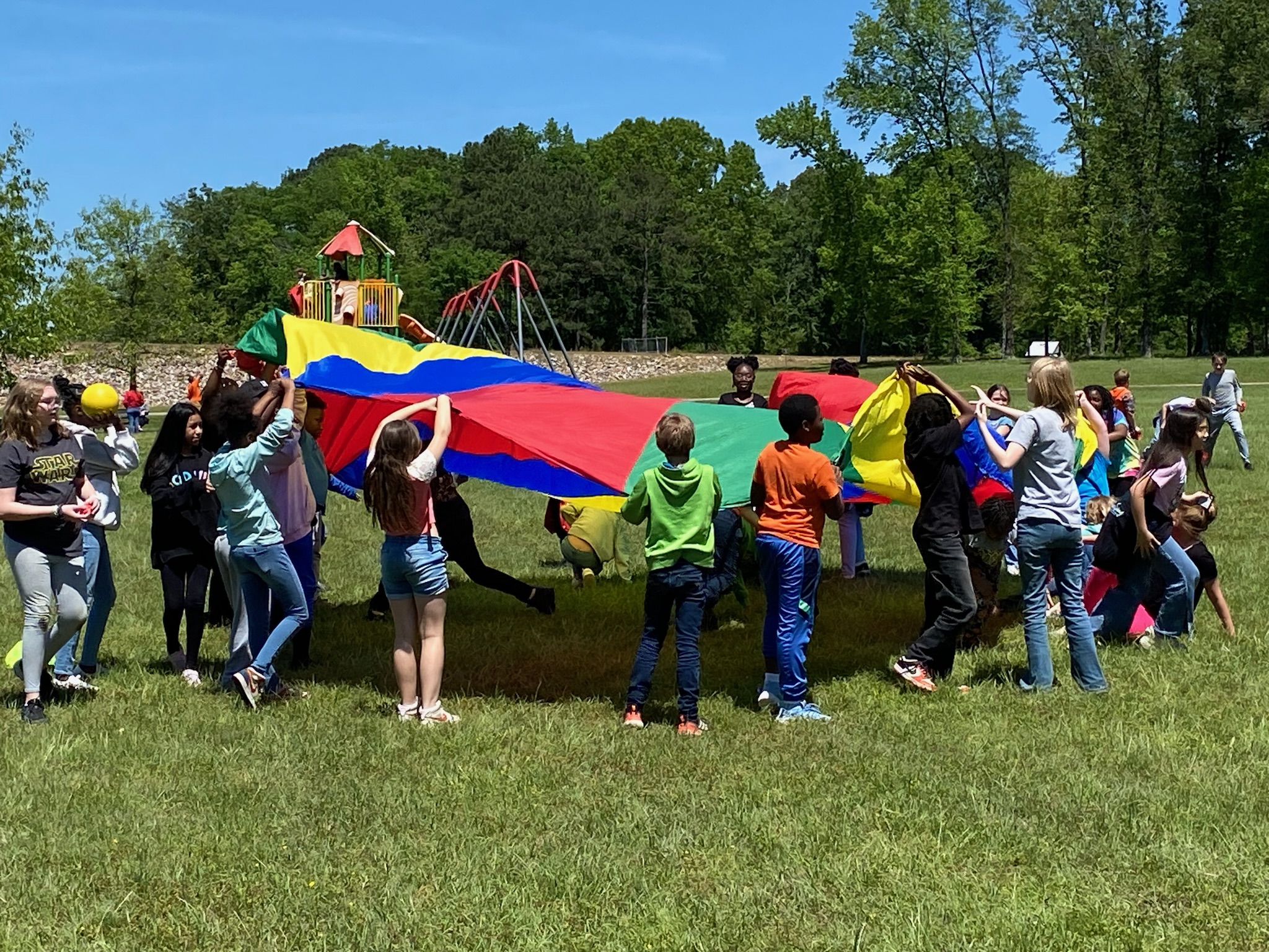 students playing with a parachute