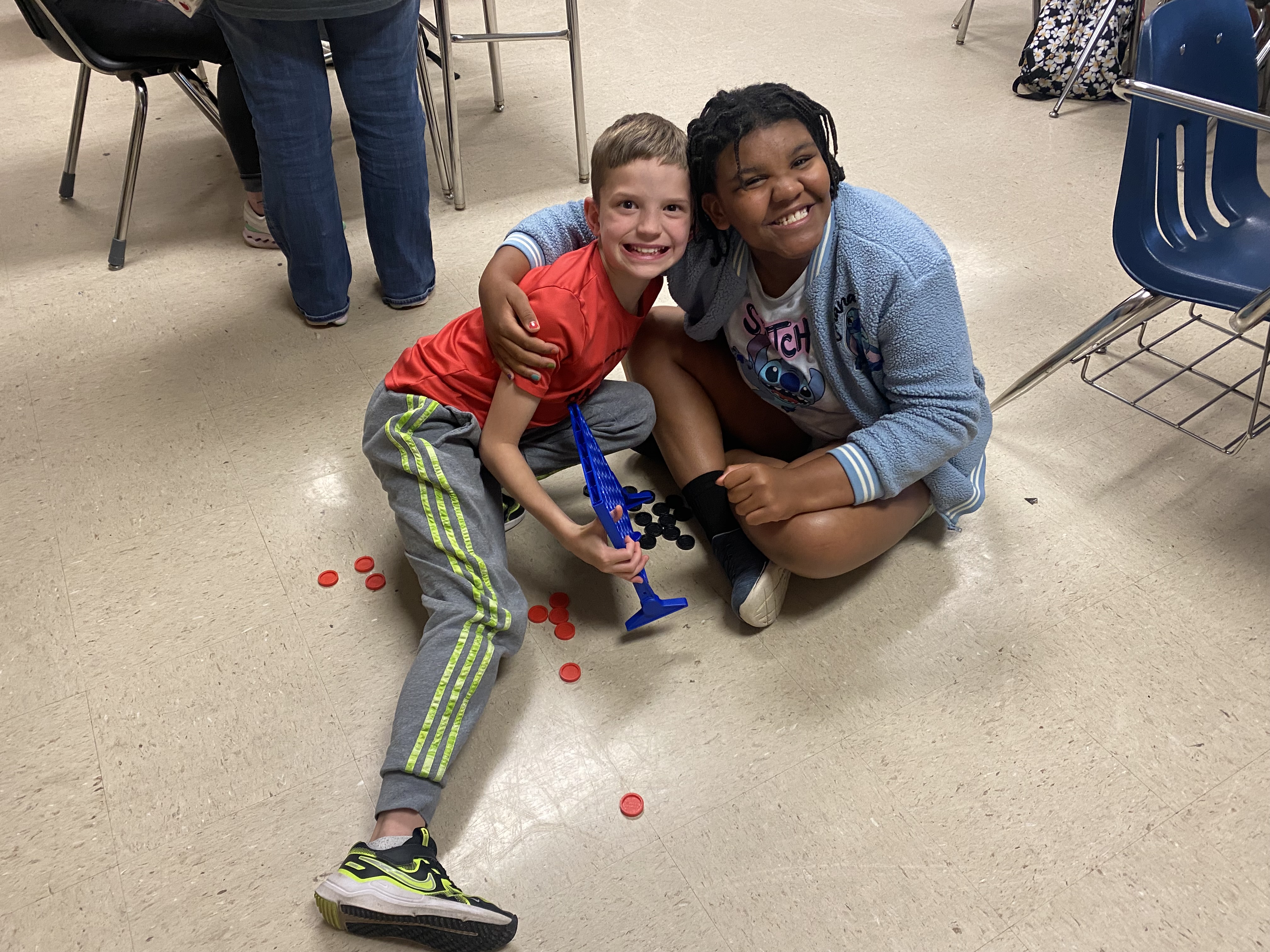 Students holding pieces of paper and smiling