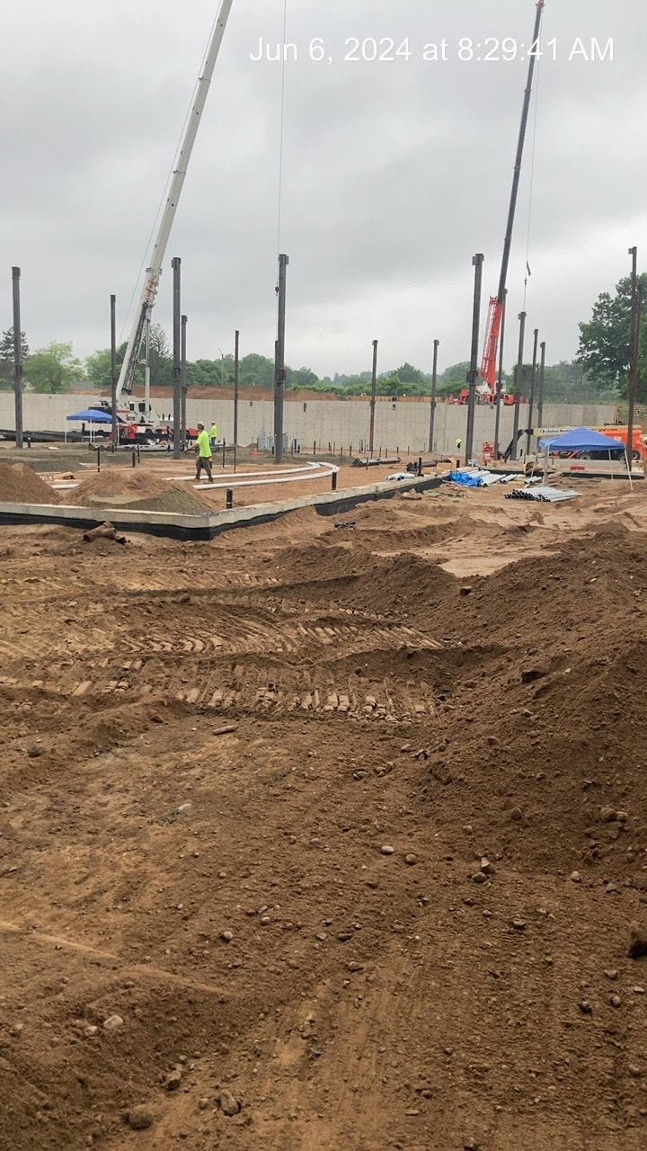 Steel beams and worker at school construction site