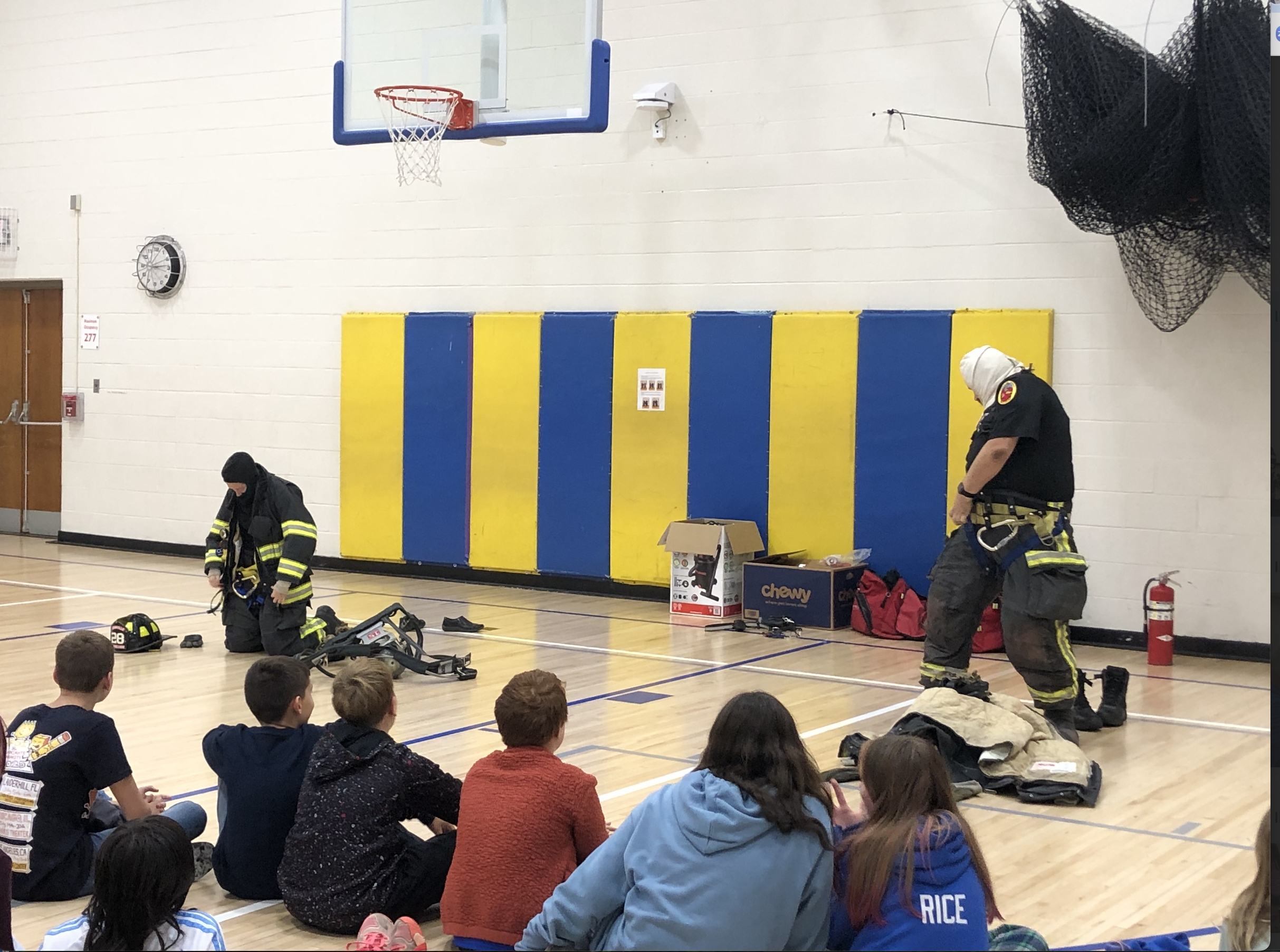 Firemen showcase how to put on their uniforms for GES students