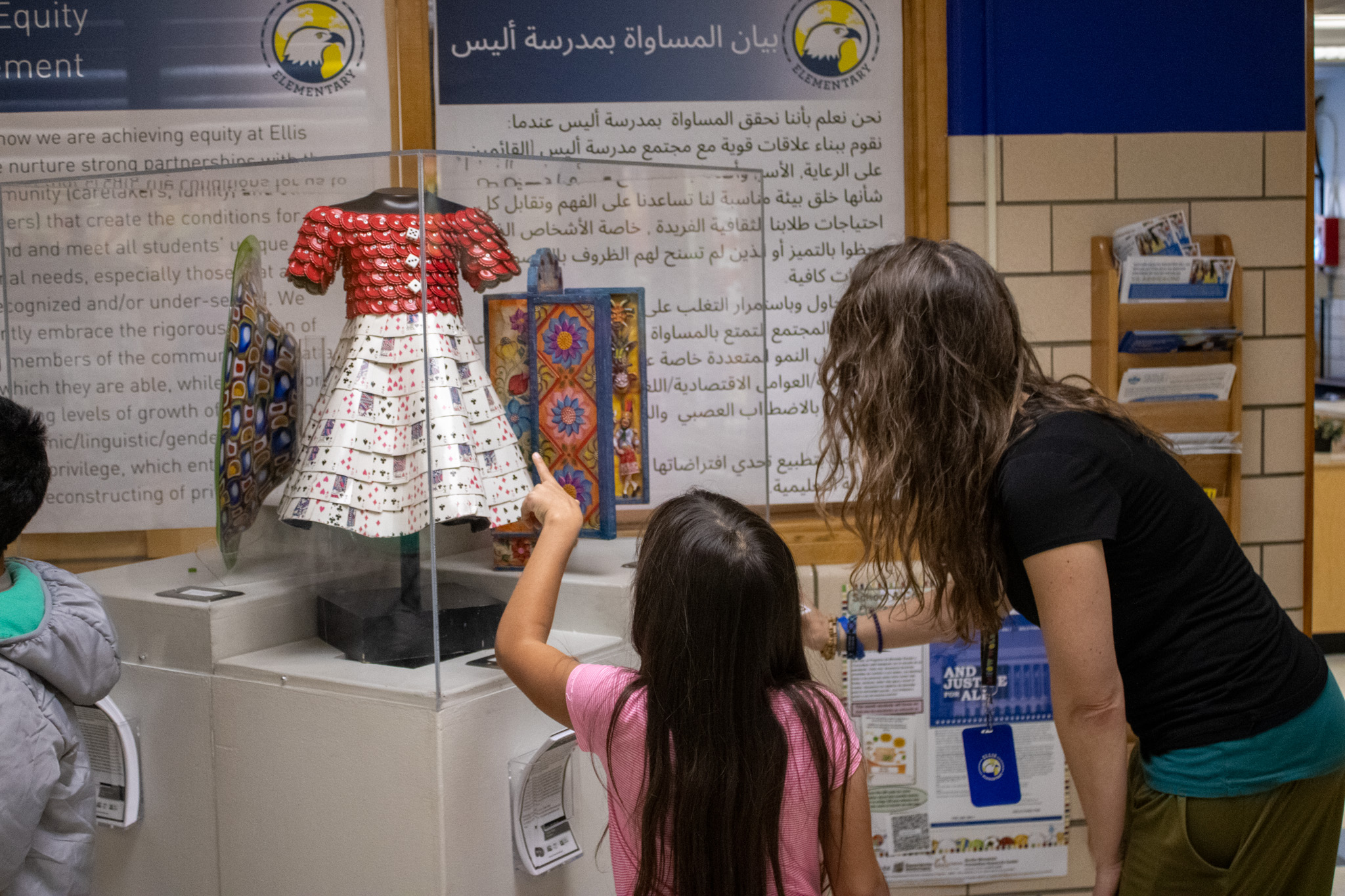 A student points at one of the art exhibits. 