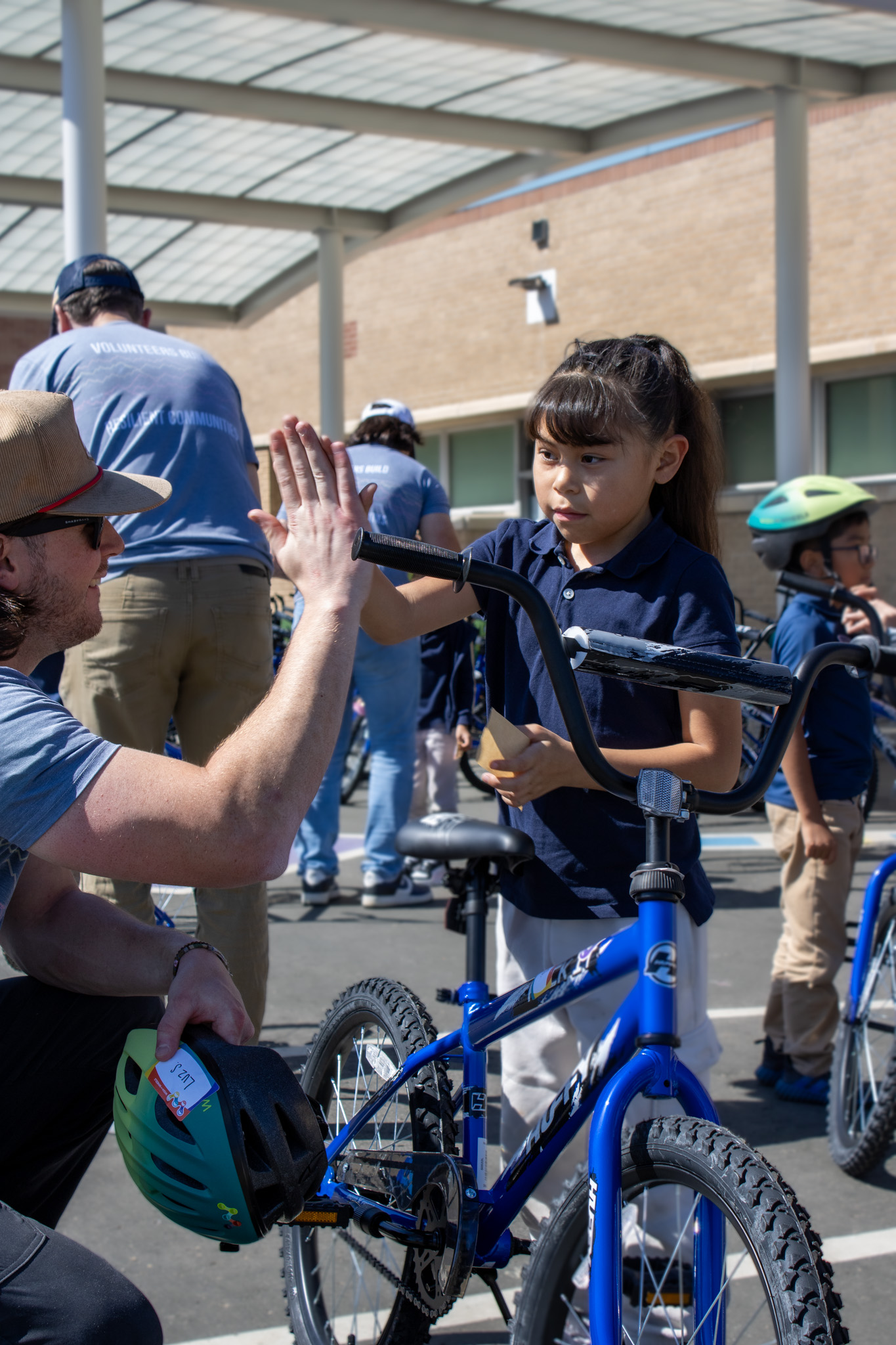 A student high-fives a Wish for Wheels volunteer. 