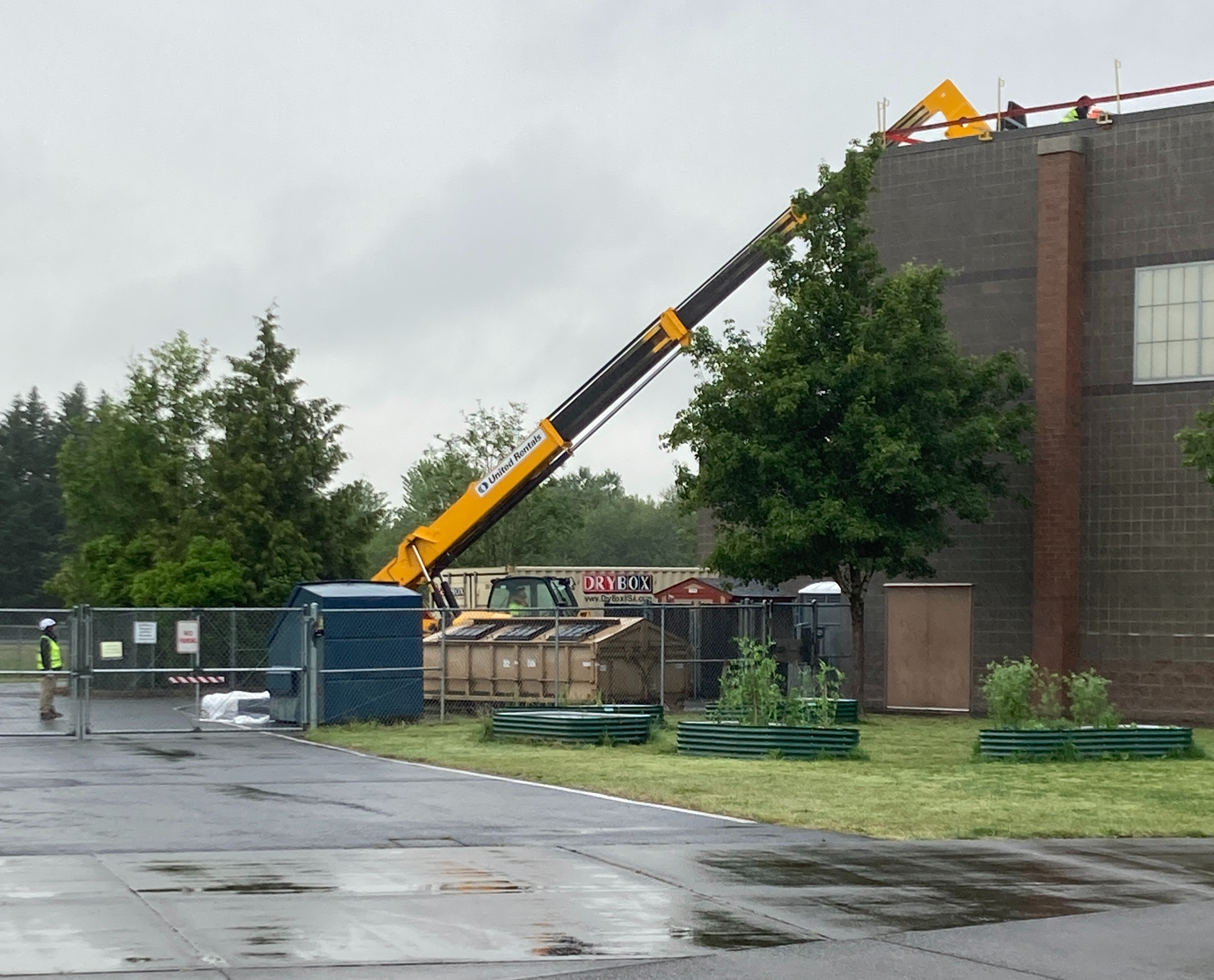A crane is used to lift roofing material onto a building