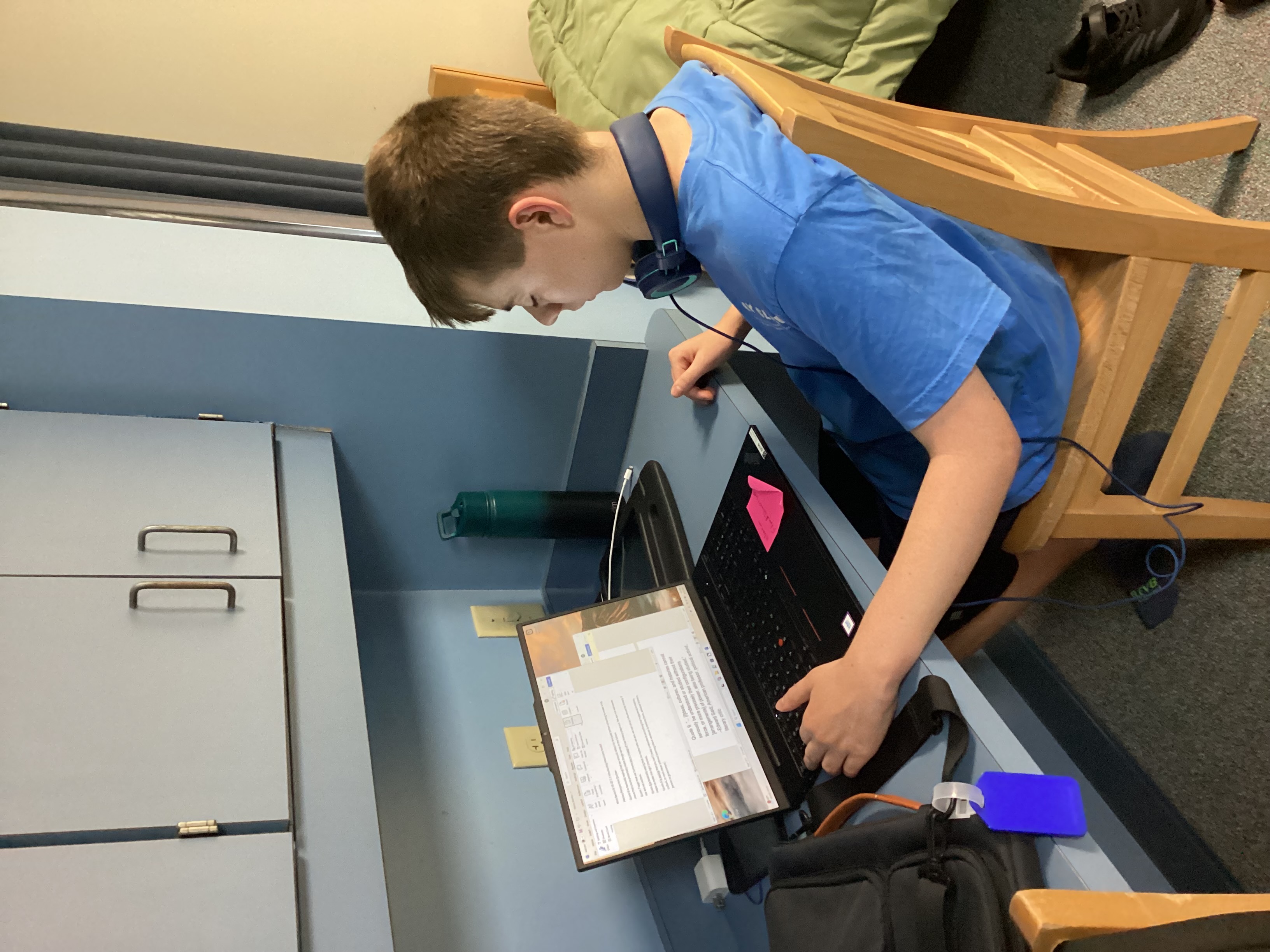Student sitting at his desk with his laptop open