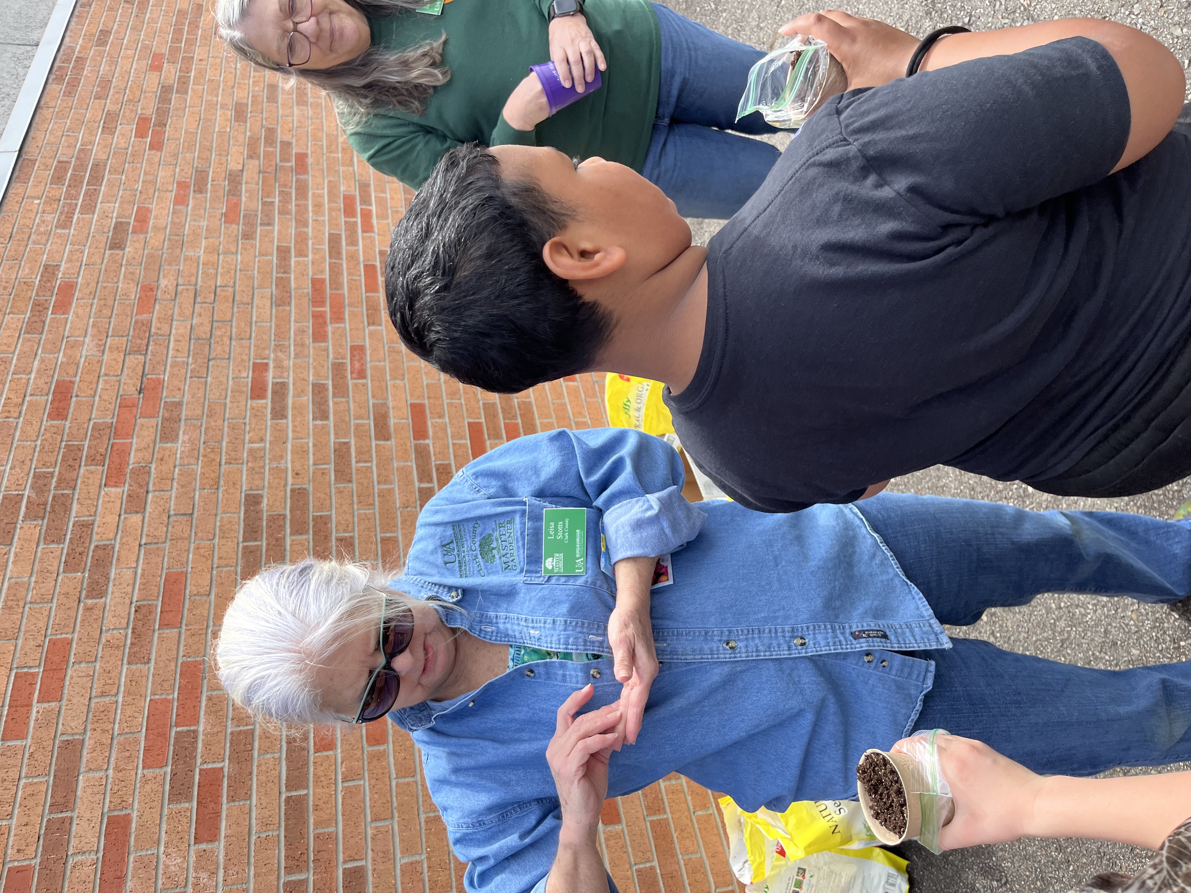 Master Gardeners helping students plant seeds
