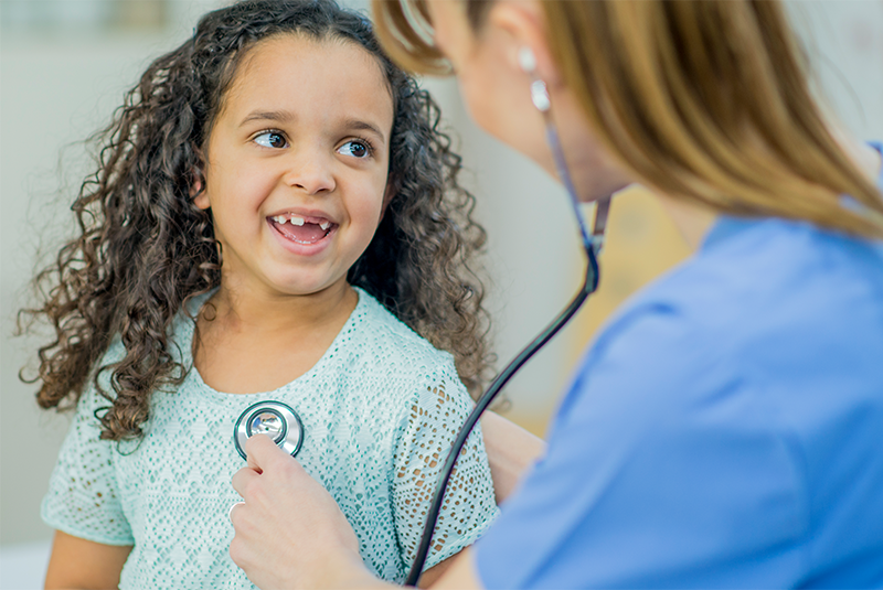 nurse using stethoscope on child