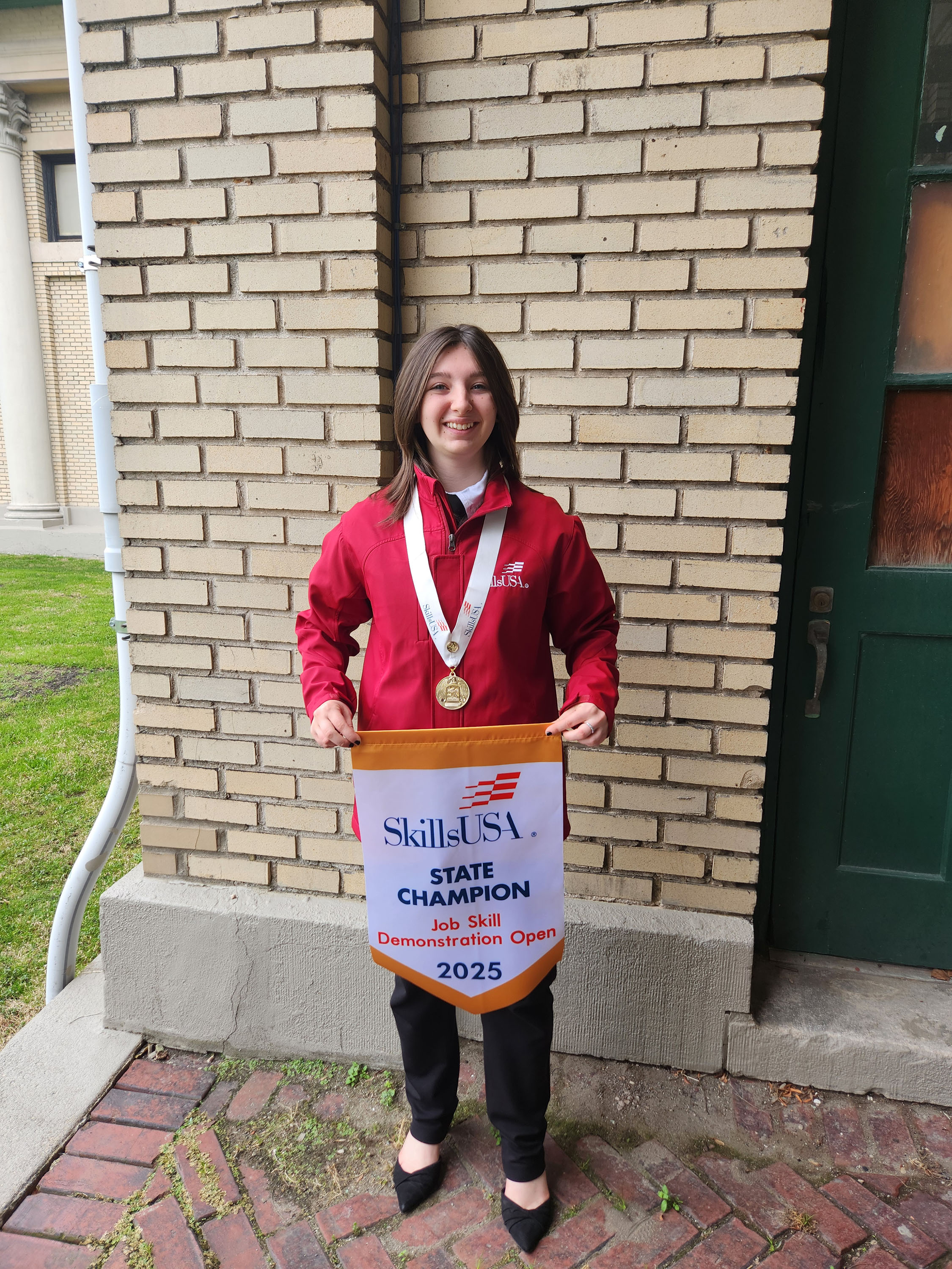SkillsUSA student with state championship banner